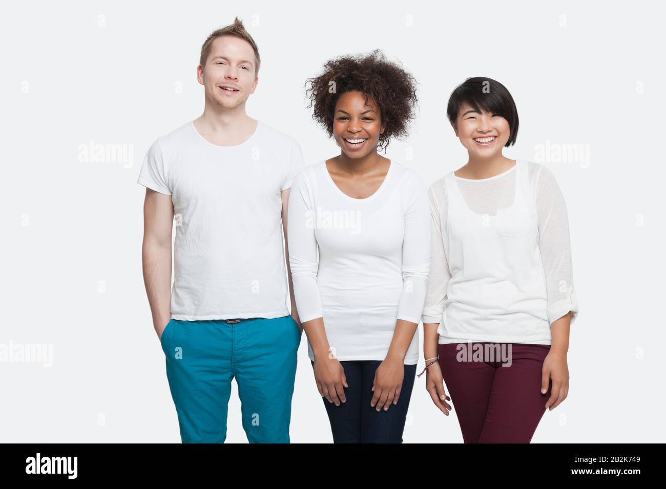 Portrait de jeunes amis multiethniques dans des casuaux debout côte à côte sur fond blanc Banque D'Images