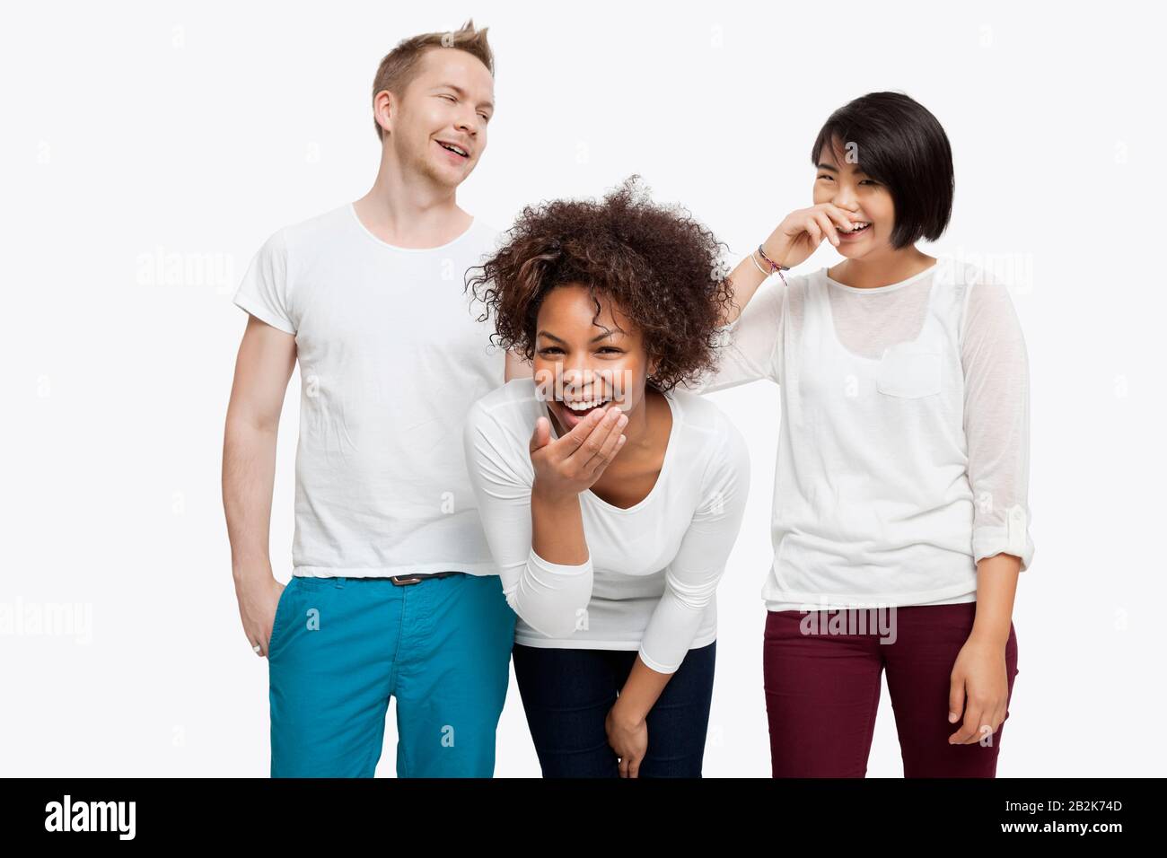 De jeunes amis multiethniques en riant sur fond blanc Banque D'Images