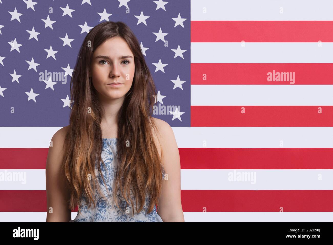 Portrait de la jeune femme contre le drapeau américain Banque D'Images