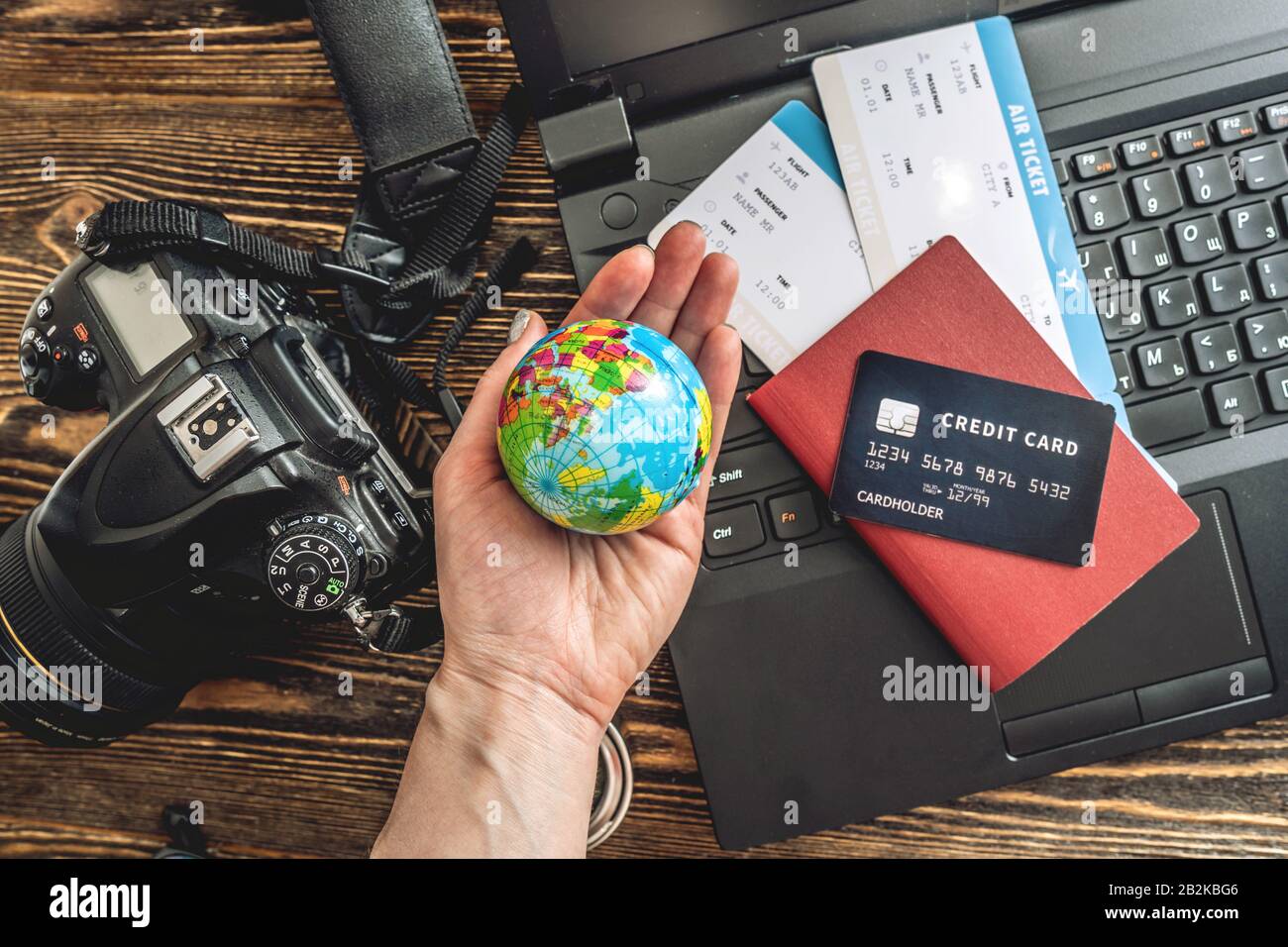 Préparez-vous à un voyage passionnant. Man livre des vols en tapant sur un ordinateur portable et en payant avec une carte de crédit sur un fond en bois. La vue du haut Banque D'Images