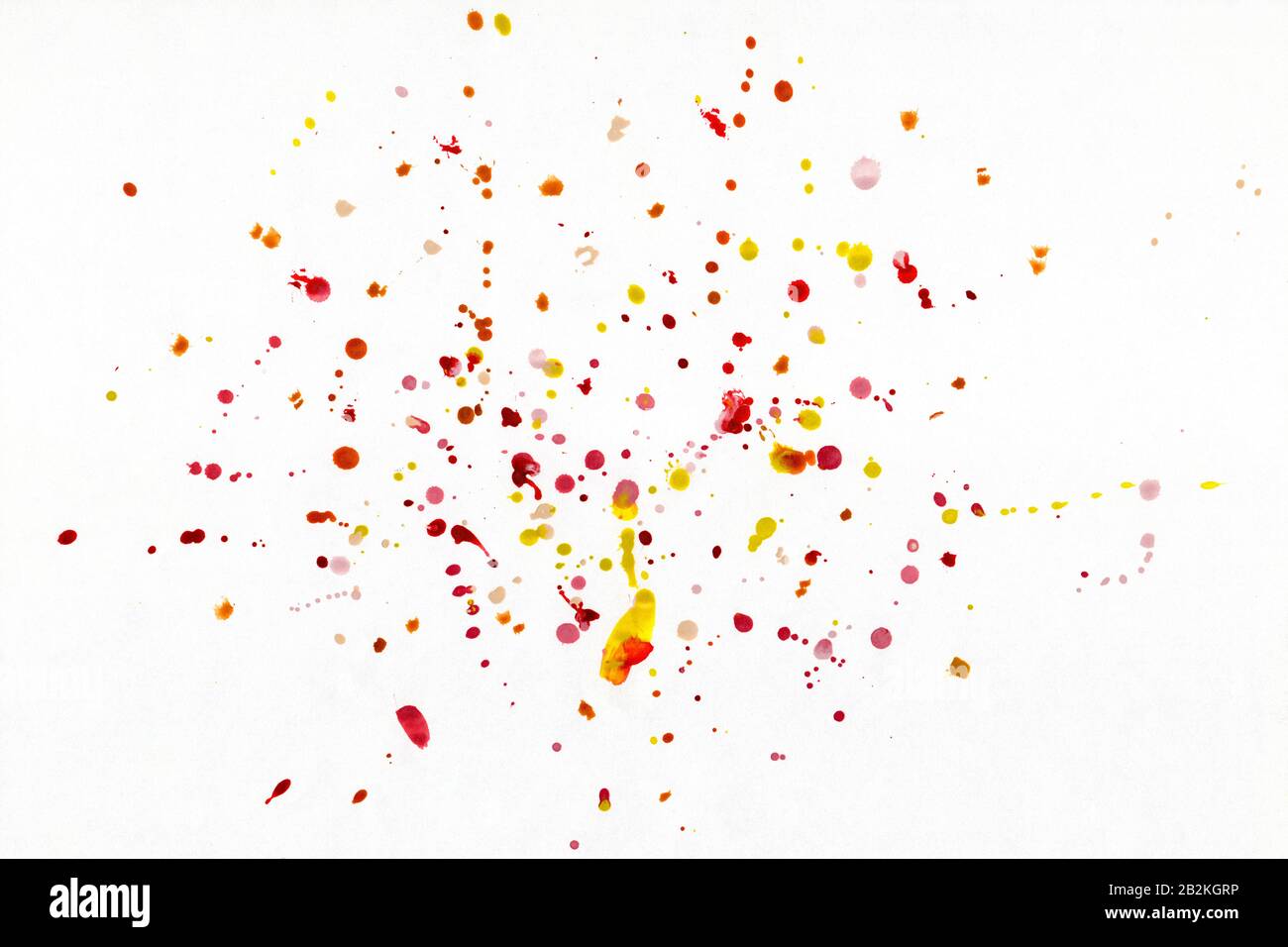 Gouttes rouges et jaunes sous forme de peinture à l'aquarelle vaporisée sur fond blanc. Banque D'Images