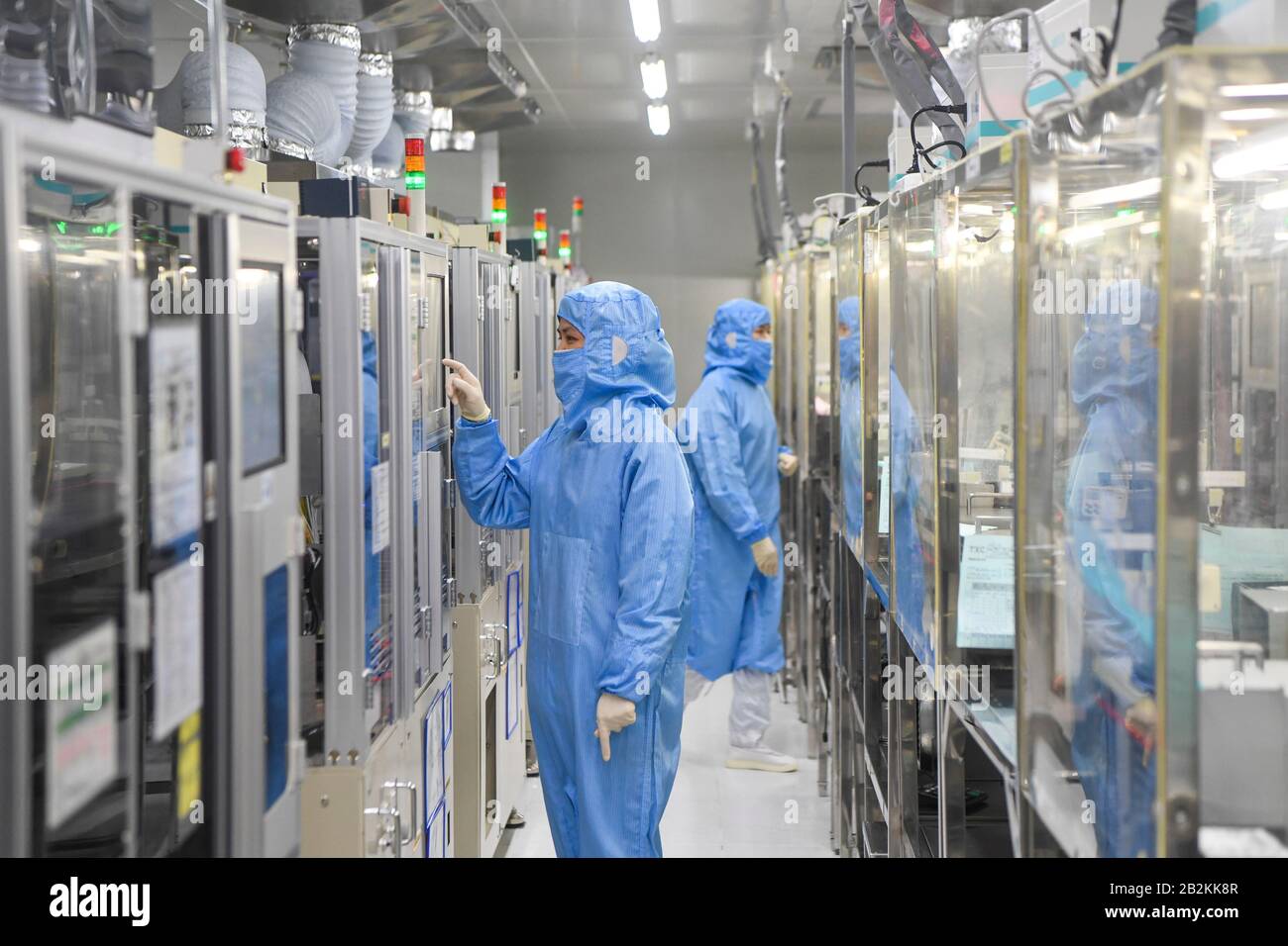 Chongqing, Chine. 3 mars 2020. Le personnel travaille à l'atelier d'emballage de l'oscillateur à quartz de la TXC (Chongqing) Corporation dans la zone de haute technologie de Chongqing, dans le sud-ouest de la Chine, le 3 mars 2020. La zone de haute technologie de Chongqing a mis en place des politiques visant à aider les entreprises à reprendre leur production lors de la lutte contre le nouveau coronavirus. Au total, 1 598 entreprises de 102 894 travailleurs de la zone ont repris leur production et leur fonctionnement d'ici à midi du mardi. Crédit: Wang Quinchao/Xinhua/Alay Live News Banque D'Images