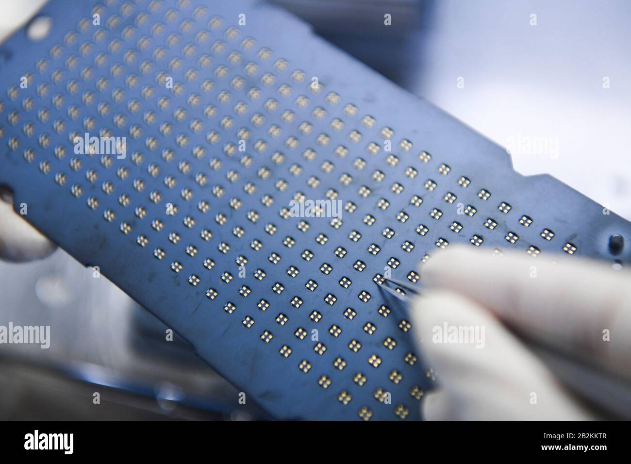 Chongqing, Chine. 3 mars 2020. Un travailleur est présent à l'atelier d'emballage de l'oscillateur à quartz de la TXC (Chongqing) Corporation dans la zone de haute technologie de Chongqing, dans le sud-ouest de la Chine, le 3 mars 2020. La zone de haute technologie de Chongqing a mis en place des politiques visant à aider les entreprises à reprendre leur production lors de la lutte contre le nouveau coronavirus. Au total, 1 598 entreprises de 102 894 travailleurs de la zone ont repris leur production et leur fonctionnement d'ici à midi du mardi. Crédit: Wang Quinchao/Xinhua/Alay Live News Banque D'Images