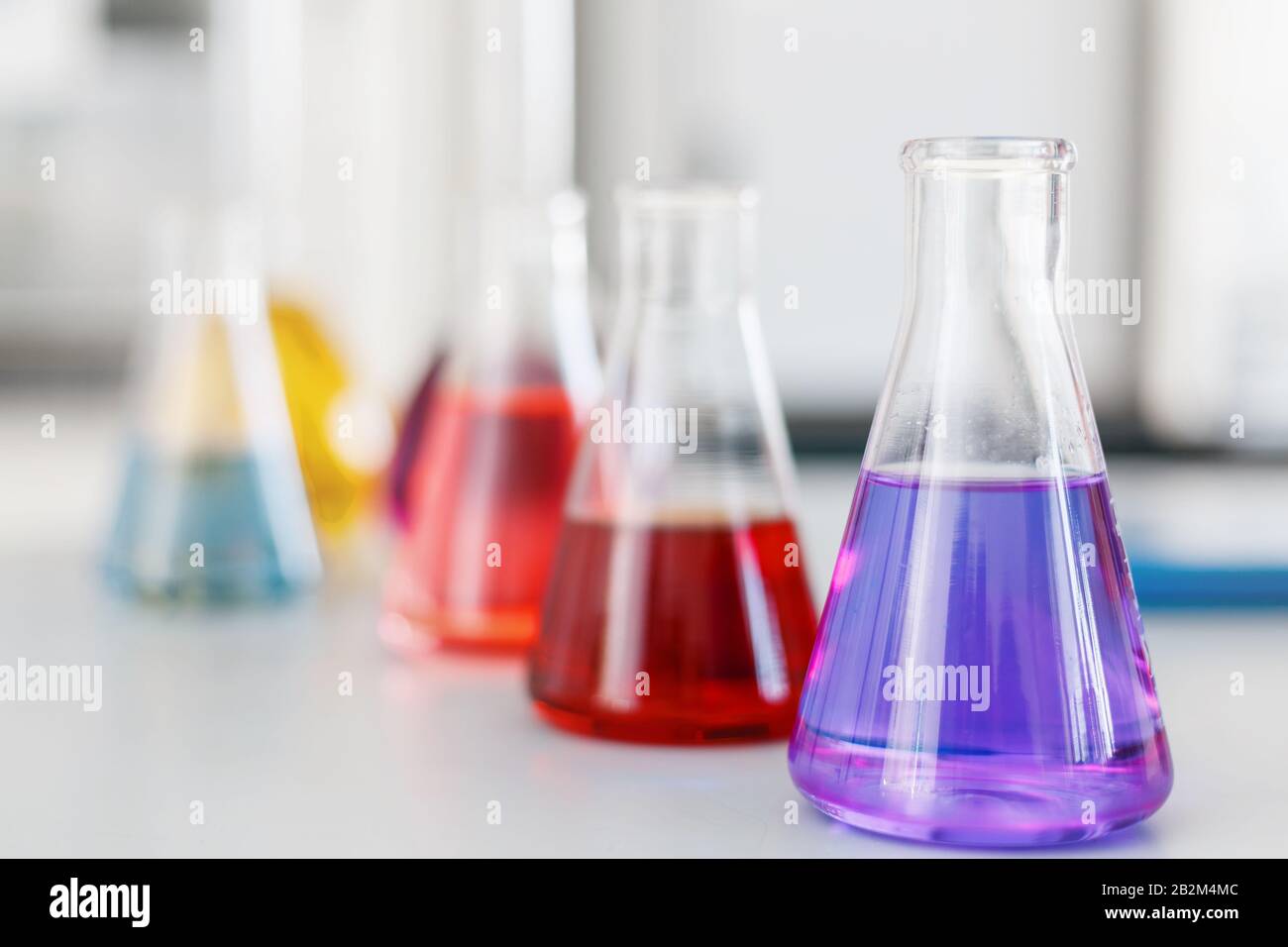 Flacon de laboratoire chimique avec support liquide bleu violet-rose sur la  table. Produits chimiques d'essais liquides de développement d'essais,  substances, poisons, additiv Photo Stock - Alamy