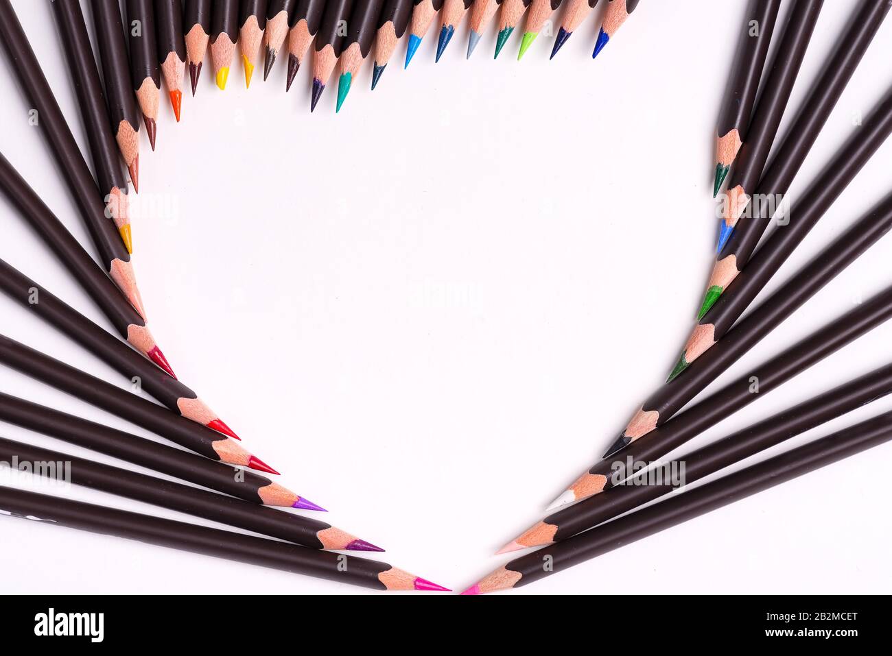 Motif de peinture à partir de crayons multicolores en forme de coeur sur un fond blanc avec espace de copie. Pose plate. Banque D'Images