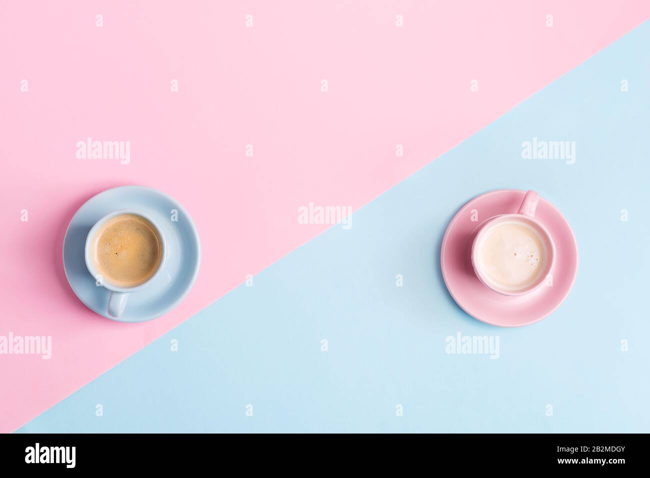 Composition décorative de deux tasses en céramique de café aromatique fraîchement préparé sur fond rose bleu pastel . Pose plate. Banque D'Images