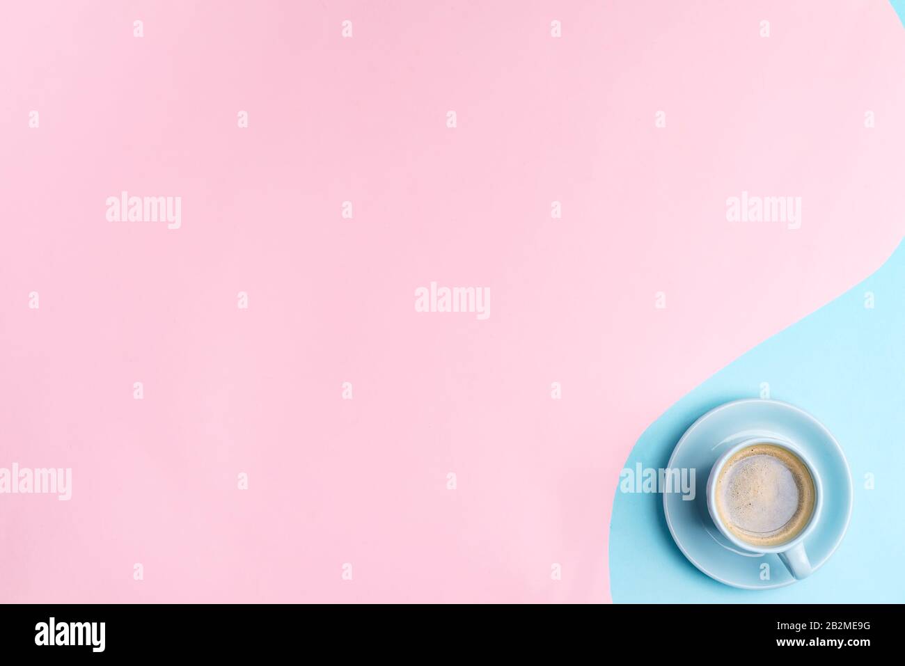 Composition décorative à partir d'une tasse de café aromatique fraîchement préparé sur fond rose bleu pastel . Pose plate. Banque D'Images