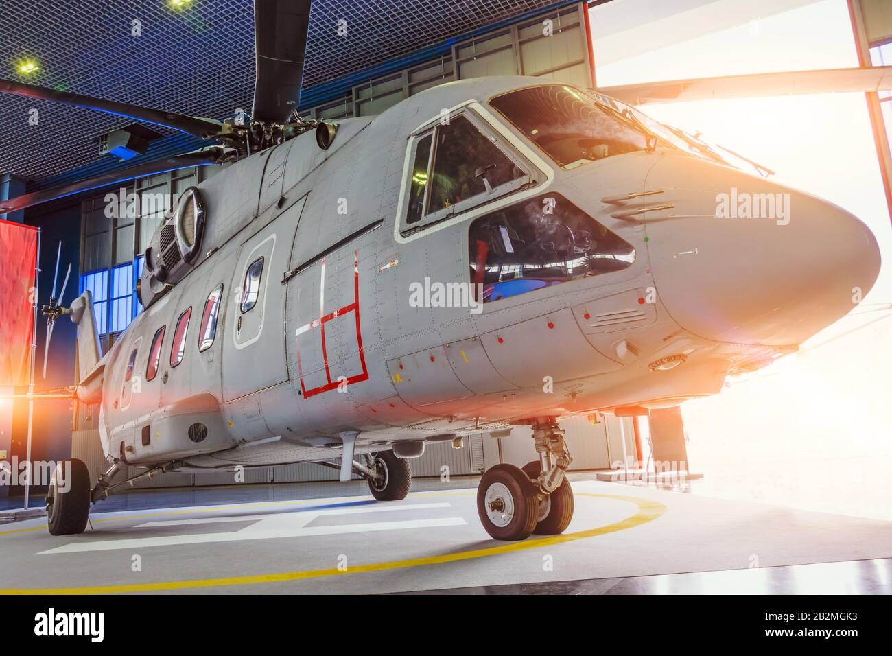 Hélicoptère dans le hangar avec portes ouvertes pour la réparation et la production Banque D'Images