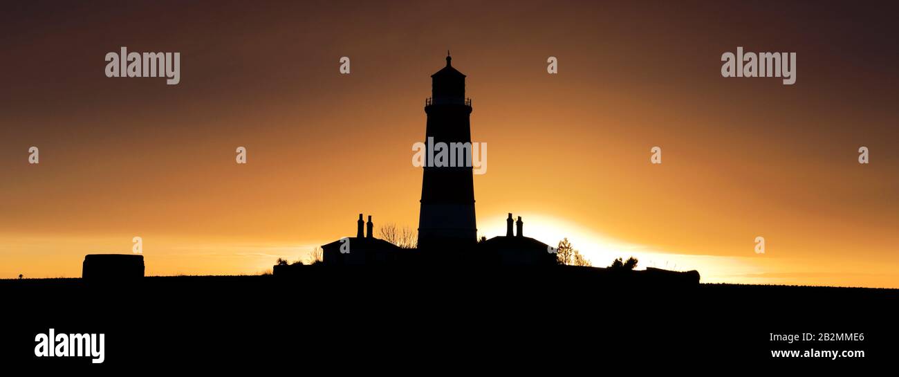 Coucher de soleil sur le phare de Happisburgh, village de Happisburgh, côte nord de Norfolk, Angleterre, Royaume-Uni son seul phare indépendant au Royaume-Uni. Banque D'Images