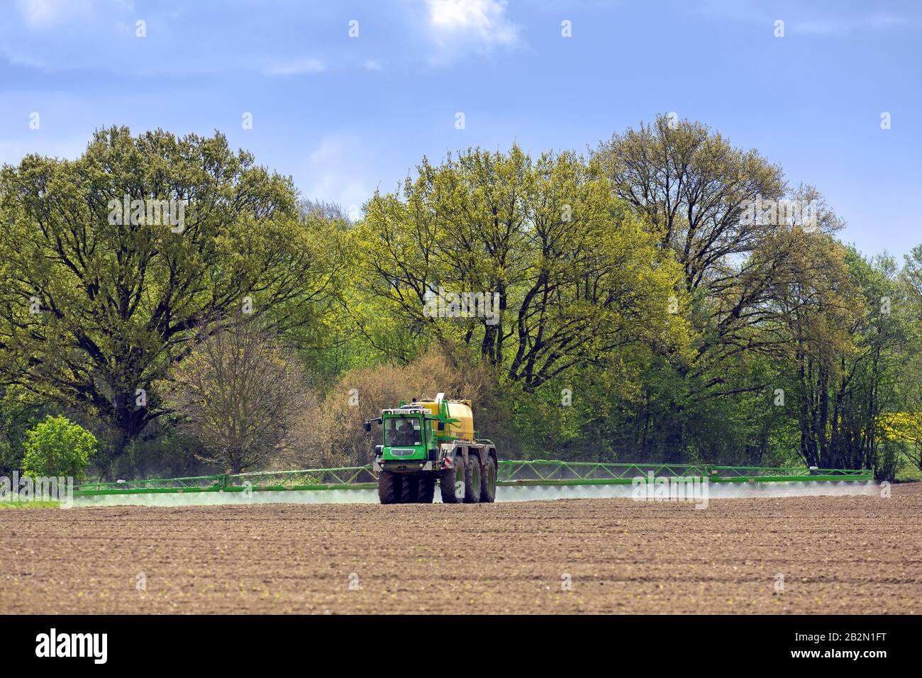 Les agriculteurs pulvérisent des pesticides / insecticides / tueurs de mauvaises herbes / herbicides sur le terrain / terres agricoles au printemps Banque D'Images