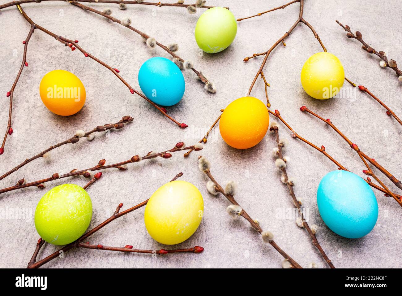 Le concept des œufs de Pâques scelle les branches sur un fond de papier peint en pierre Banque D'Images