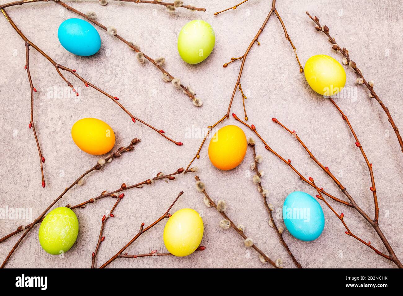 Le concept des oeufs de Pâques scelle les branches sur un fond de papier peint en pierre, vue de dessus Banque D'Images