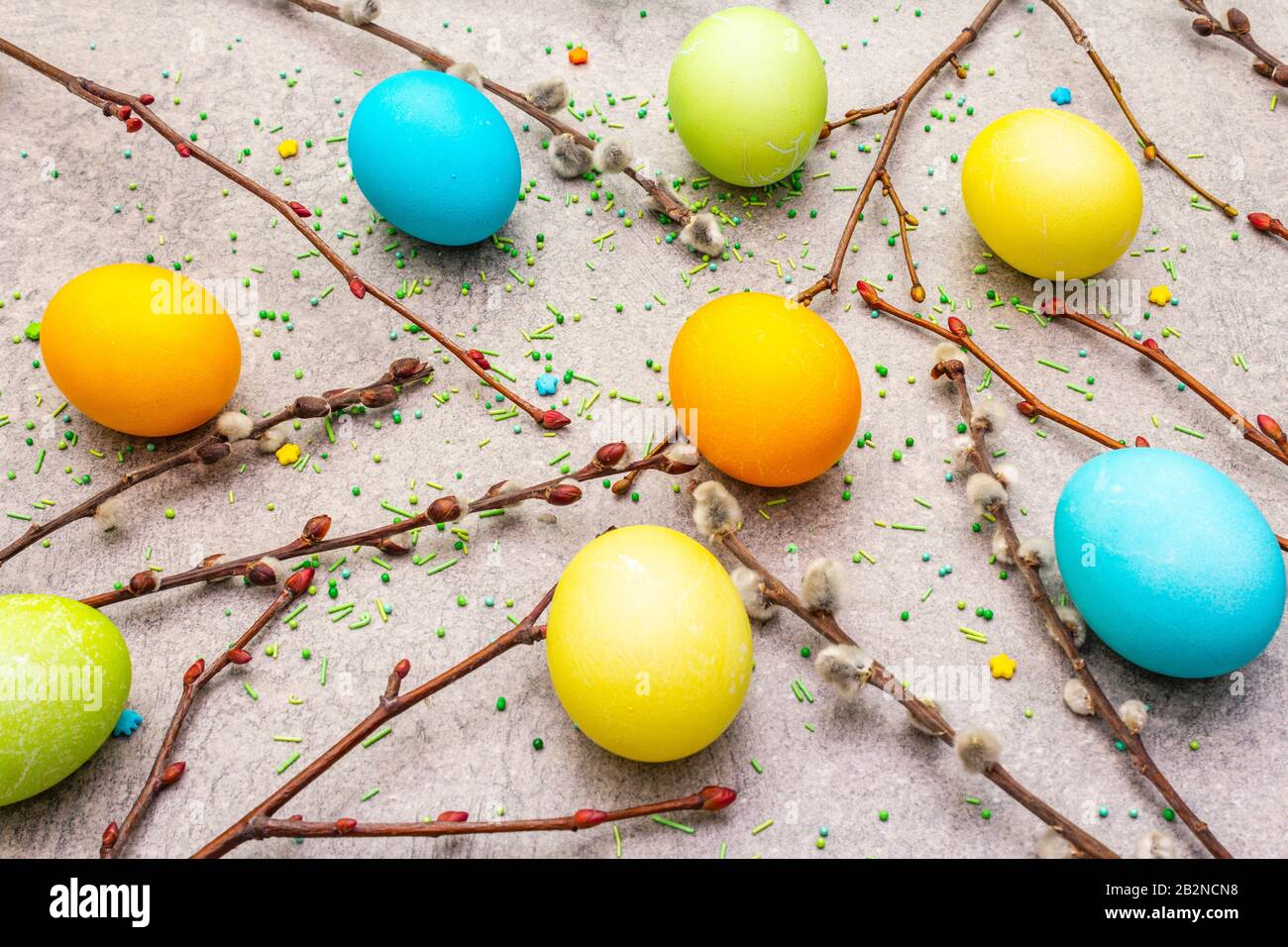 Le concept des oeufs de Pâques scelle les branches, la garniture douce sur un fond de papier peint en pierre Banque D'Images