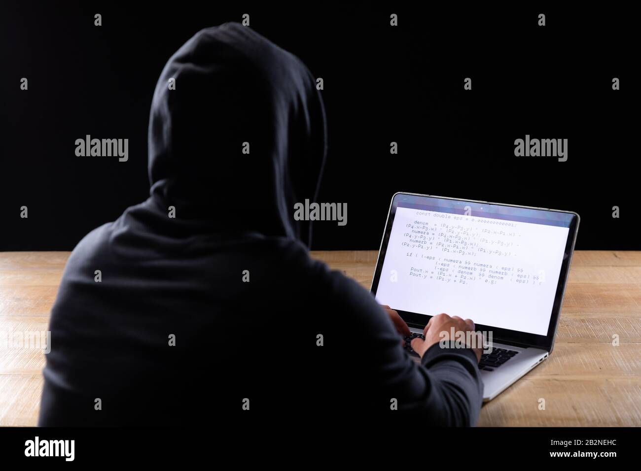 Homme caucasien travaillant sur un ordinateur portable sur fond noir Banque D'Images
