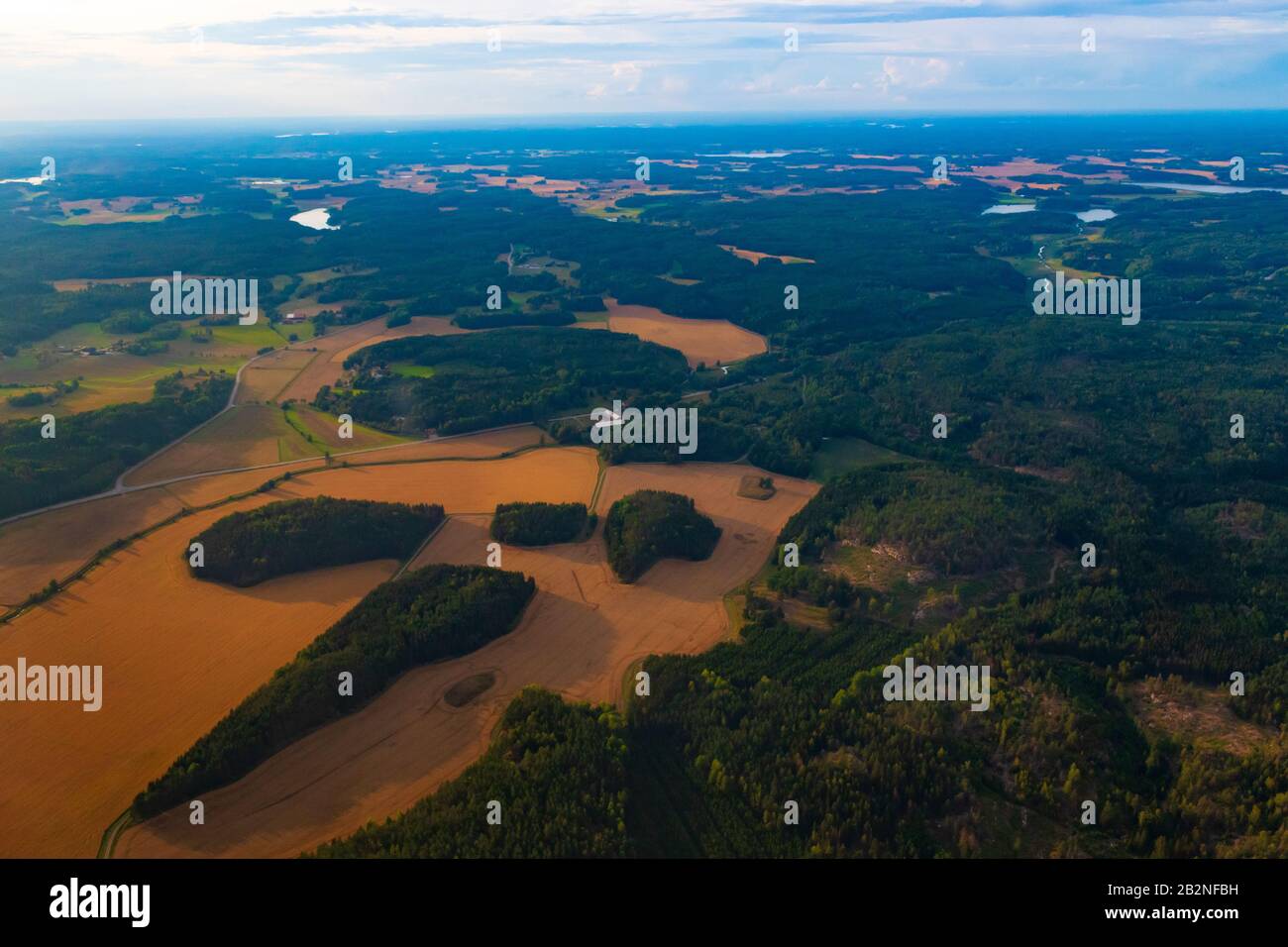 Vue aérienne de la campagne suédoise avec les terres agricoles, les forêts vertes et les champs de blé vus de l'avion volant à l'aéroport de Scavsta après la tempête estivale Banque D'Images