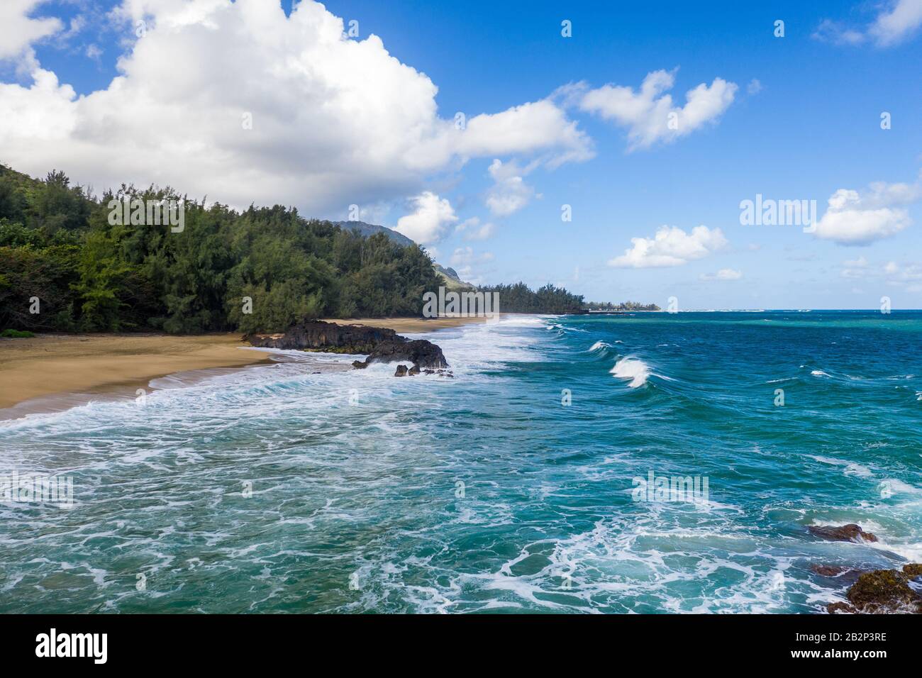 Image panoramique aérienne au large de la côte sur la plage de Lumaha'i sur l'île hawaïenne de Kauai avec les montagnes de Na Pali derrière Banque D'Images