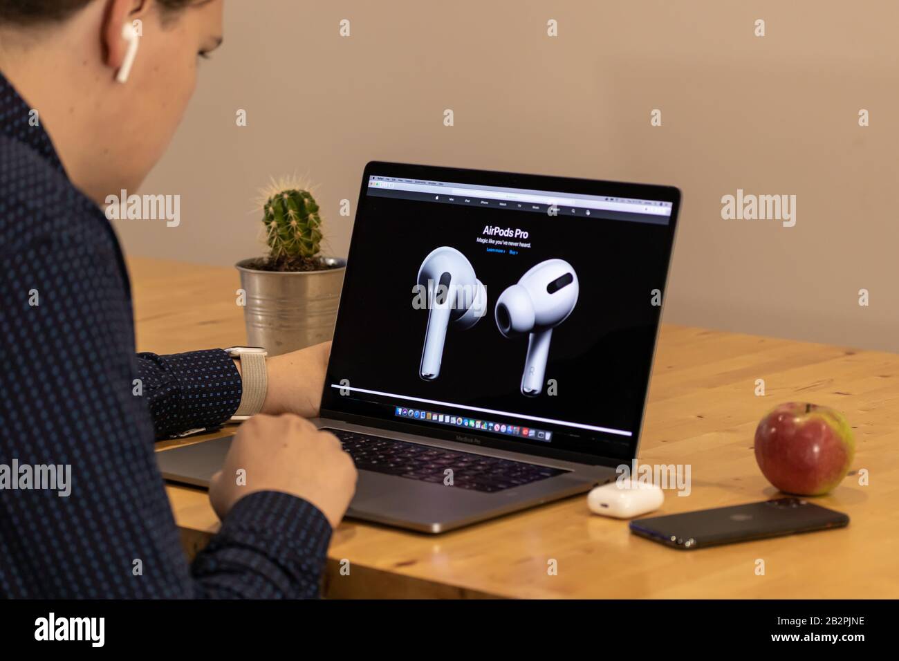 Homme regardant le nouveau Apple AirPods Pro sur le site web Apple via un MacBook Pro. Banque D'Images