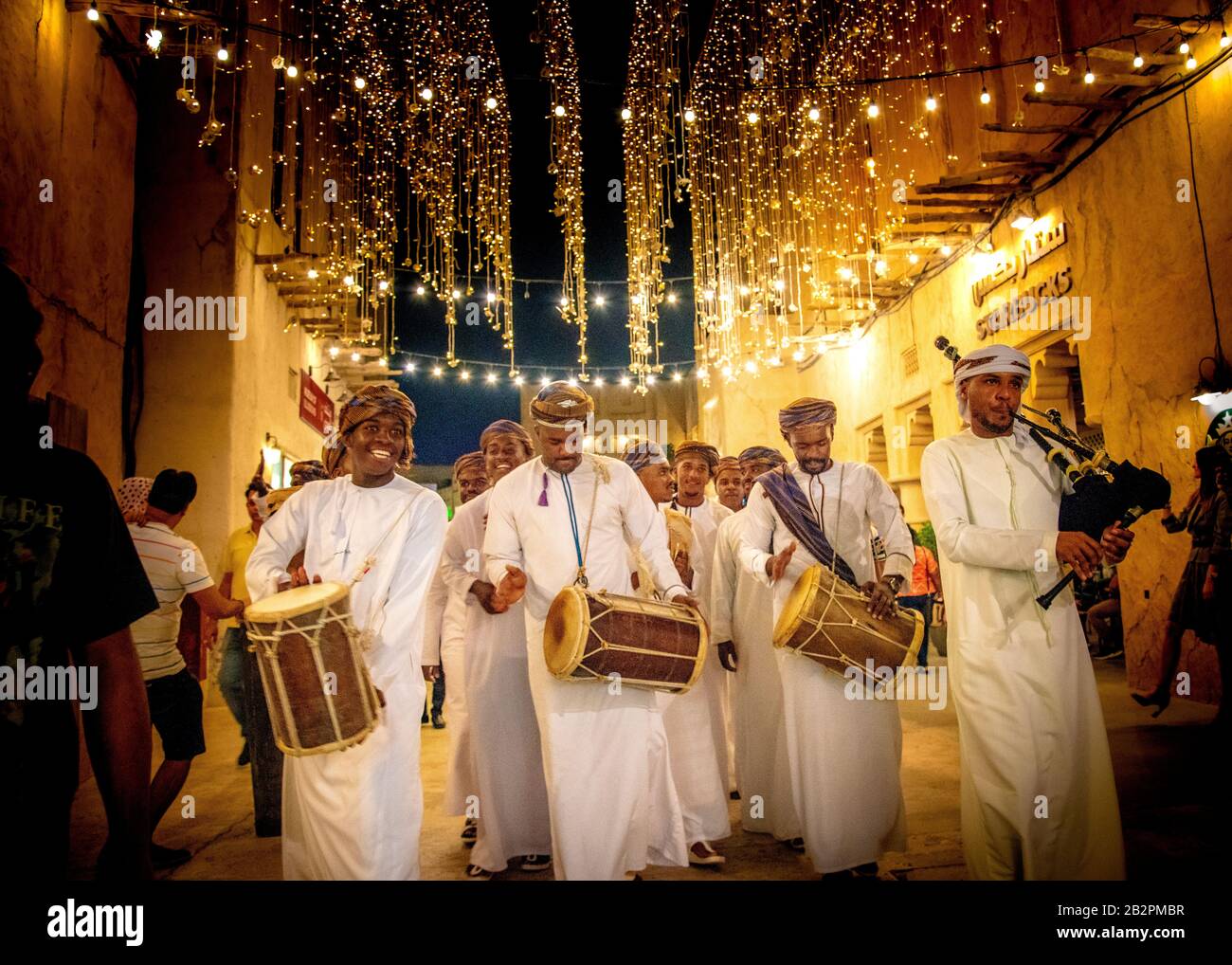 street Entertainer, en robe traditionnelle marchant dans la vieille ville, Dubaï, la nuit Banque D'Images