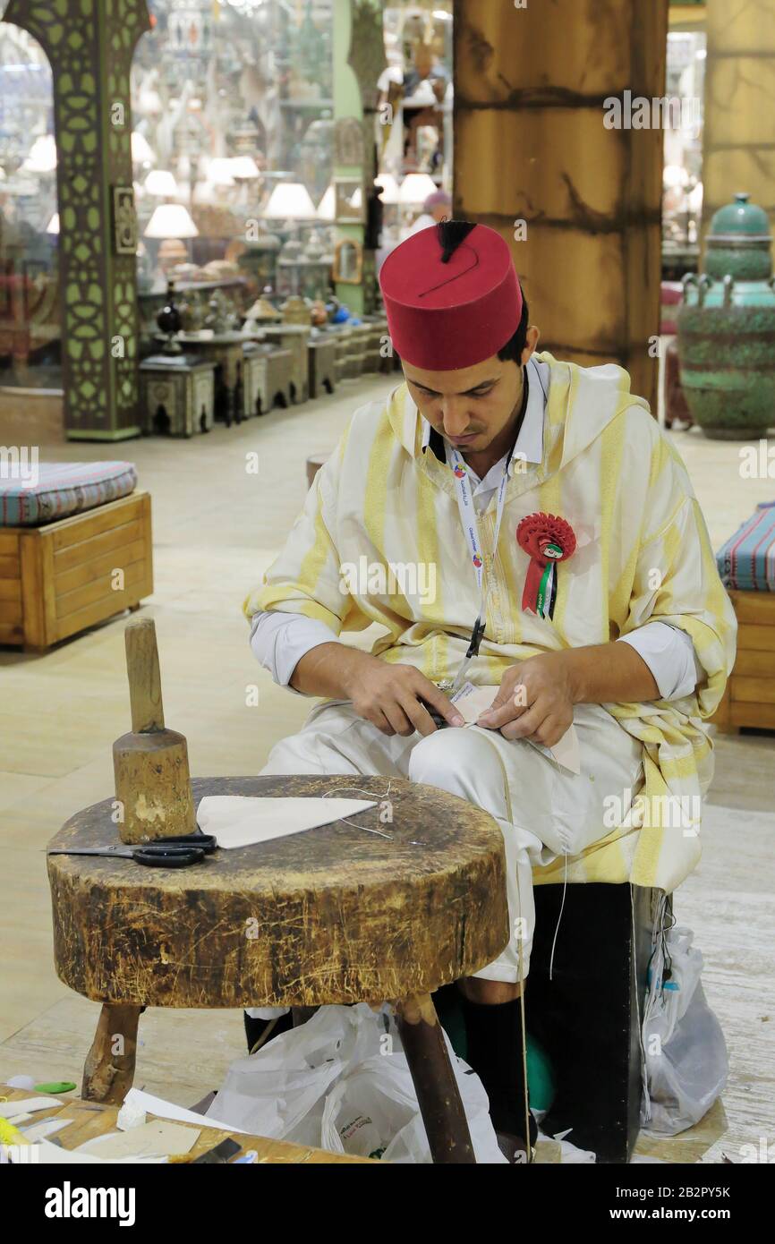 Dubaï, Émirats arabes Unis - 4 DÉCEMBRE 2017 : artisan du cordonnier dans des vêtements nationaux dans le pavillon de la Turquie dans Global Village Banque D'Images