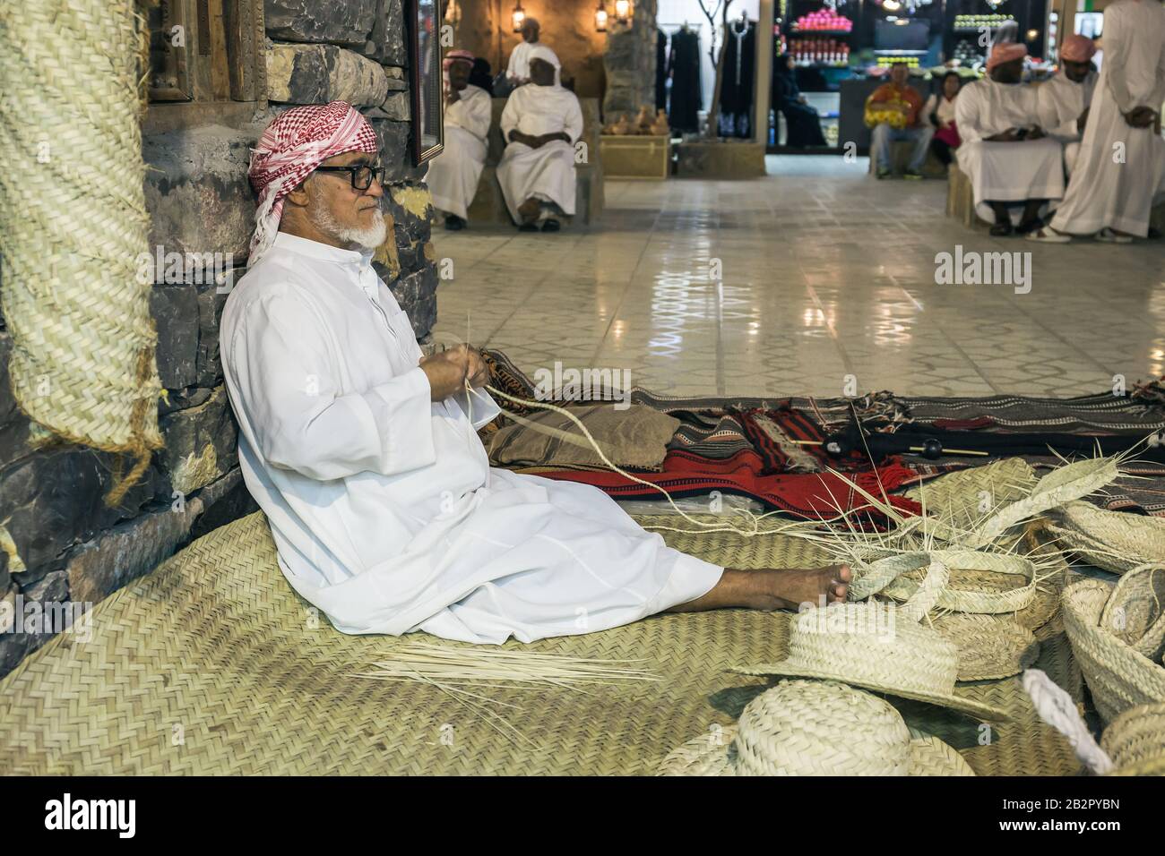 Dubaï, Émirats arabes Unis - 4 DÉCEMBRE 2017 : le vieil homme serpente des chapeaux de paille pour rencontrer des invités dans le pavillon des Émirats arabes Unis, Global Village Banque D'Images