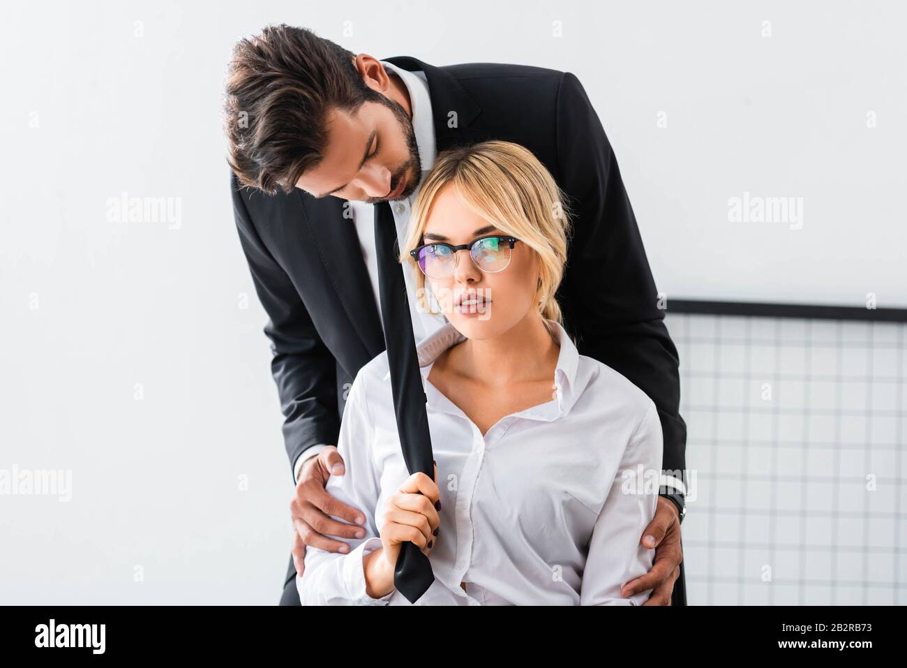 Femme d'affaires sexy tirant le lien de l'homme d'affaires au bureau Photo  Stock - Alamy