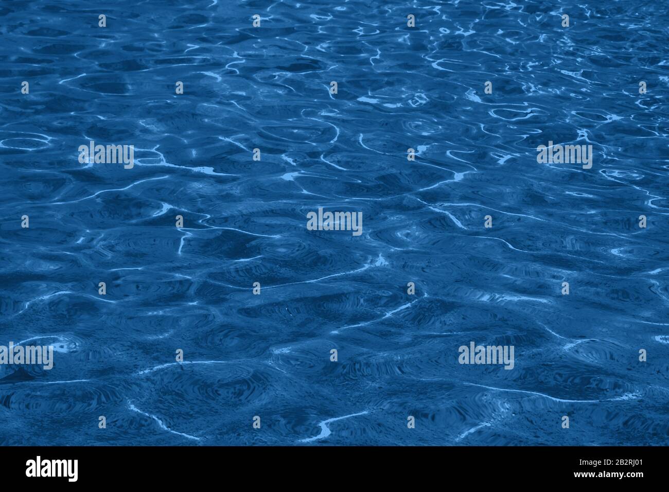 Surface de l'eau avec des reflets et des ondulations dans Pantone classic blue 2020. Couleur de l'année. Arrière-plan naturel abstrait. Photo monochrome. Banque D'Images