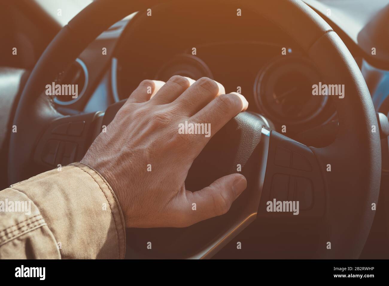 Actionner l'avertisseur sonore de la voiture en cas de bourrage de circulation, gros plan sur la main mâle du volant du véhicule avec mise au point sélective Banque D'Images