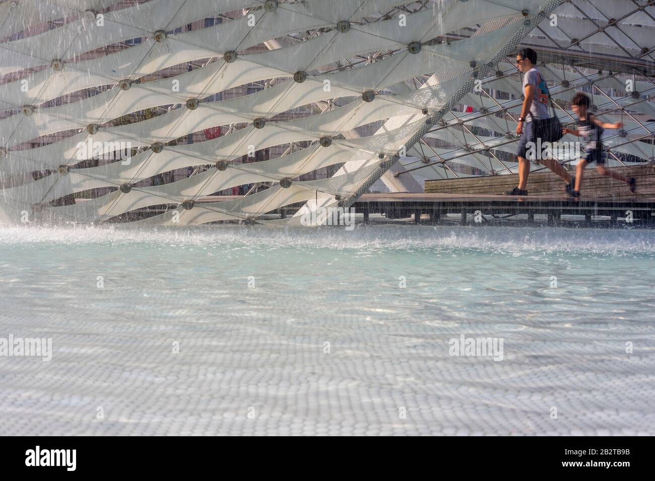 Un homme marche et un enfant passe par la fontaine de la liberté (Fontanna Wolnosci) sur la place de la liberté (Plac Wolnosci) à Poznan, Pologne 2019. Banque D'Images