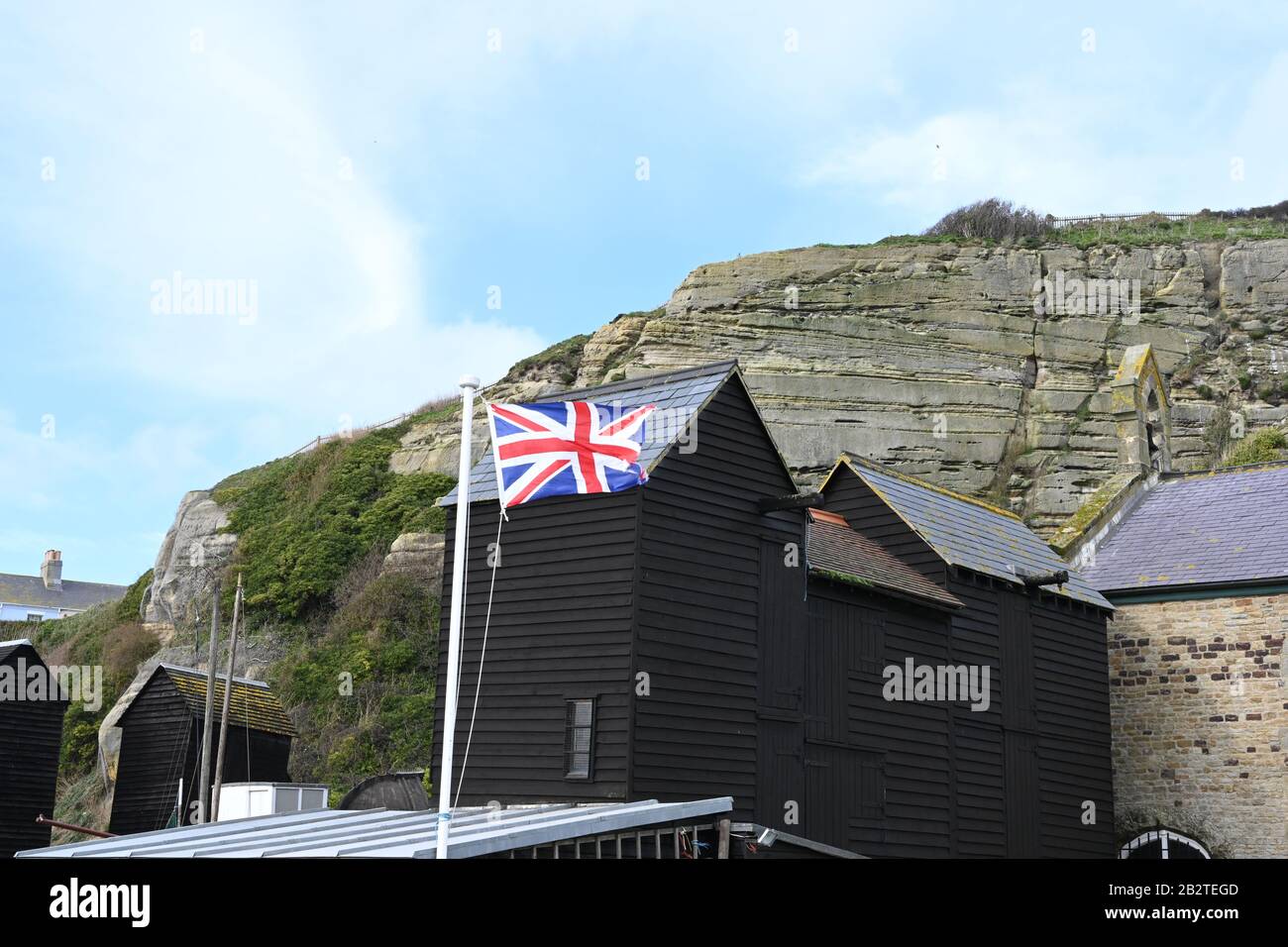 Hastings Angleterre montrant des cabanes de pêche et l'Union Jack voler Banque D'Images