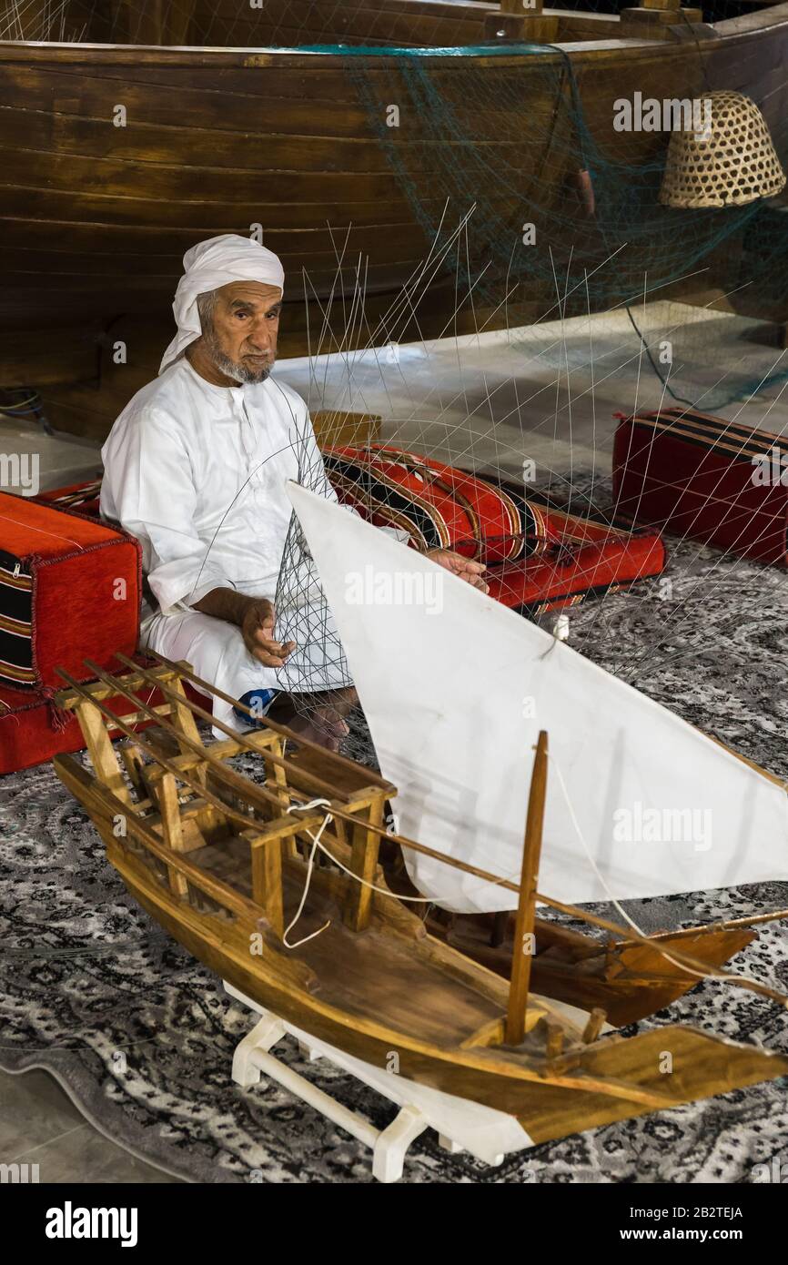 Dubaï, Émirats arabes Unis - 4 DÉCEMBRE 2017: Le vieil homme est en tissage un filet de pêche pour rencontrer des invités dans le pavillon des Émirats arabes Unis, Global Village Banque D'Images