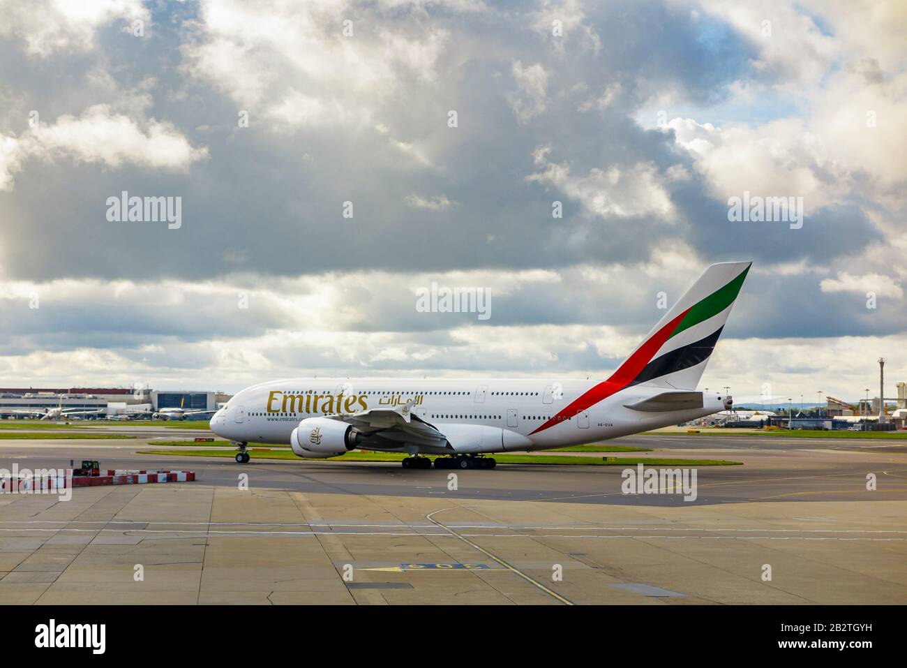 Emirates Airbus A 380-861 en privilège d'entreprise debout sur la piste de l'aéroport Heathrow de Londres sur la piste en attente de décollage sous de lourds nuages sombres Banque D'Images