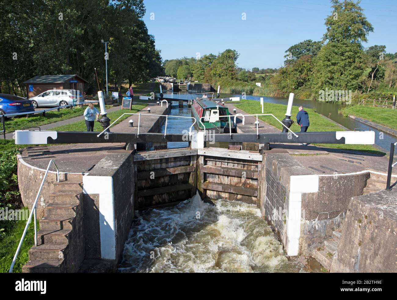 Les gens qui ouvrent une écluse pour un bateau à narrowboat ou un bateau sur le canal Grand Union, Hatton Locks, Hatton, Warwickshire, Angleterre Banque D'Images