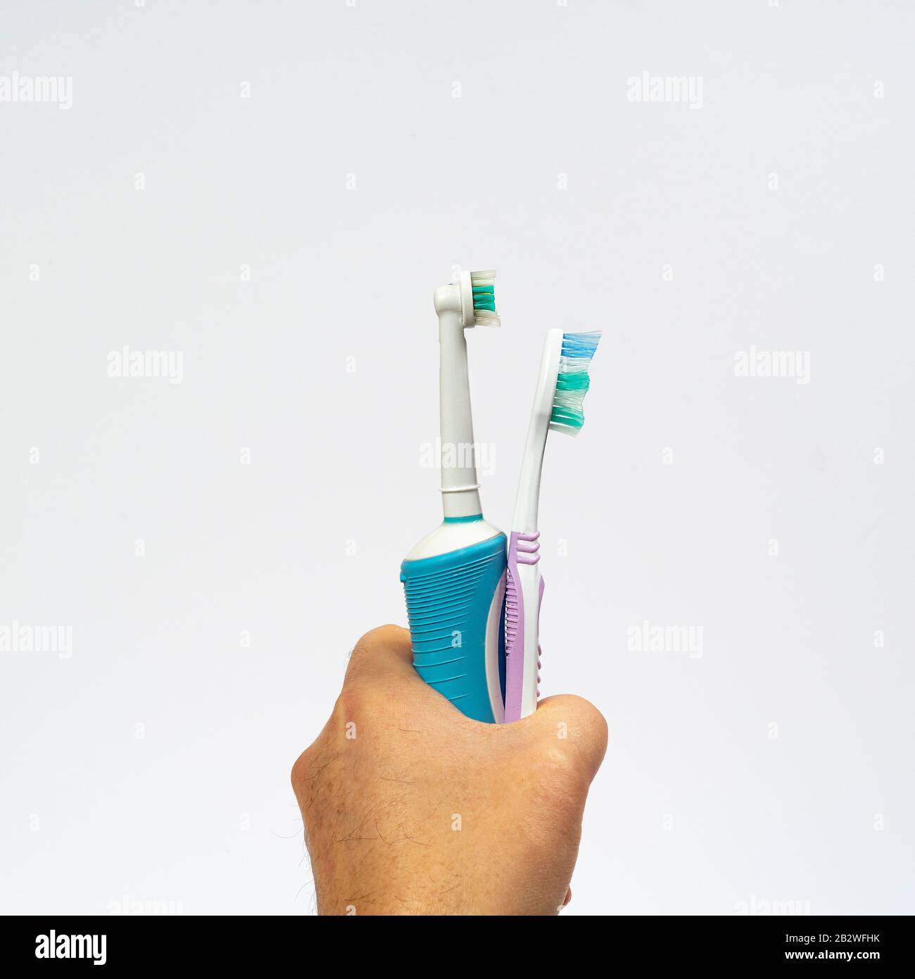 une brosse à dents électrique et une brosse à dents traditionnelle à la main Banque D'Images