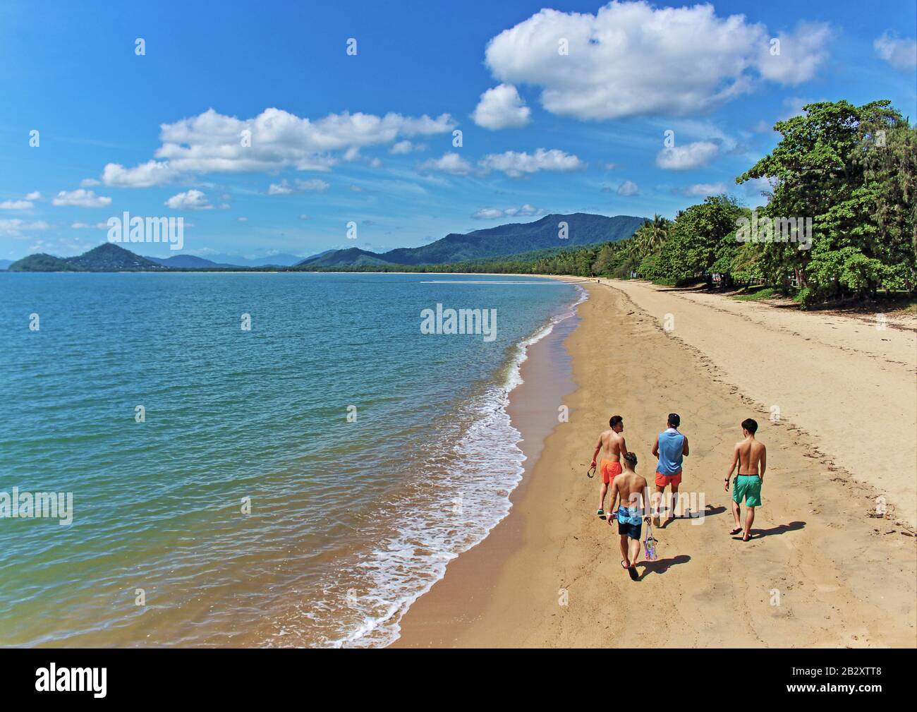 Un groupe de visiteurs asiatiques se sont mis sur leur matin constitutionnel vers le bas l'une des meilleures plages pour une telle promenade, à savoir Palm Cove Beach, Cairns, QLD au Banque D'Images