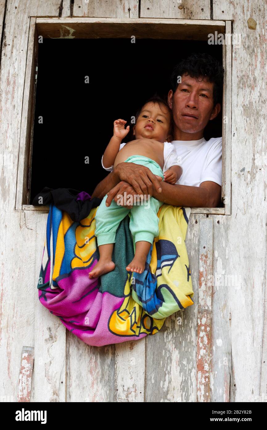 Père et fils à leur fenêtre en Amazonie équatorienne Shack Banque D'Images