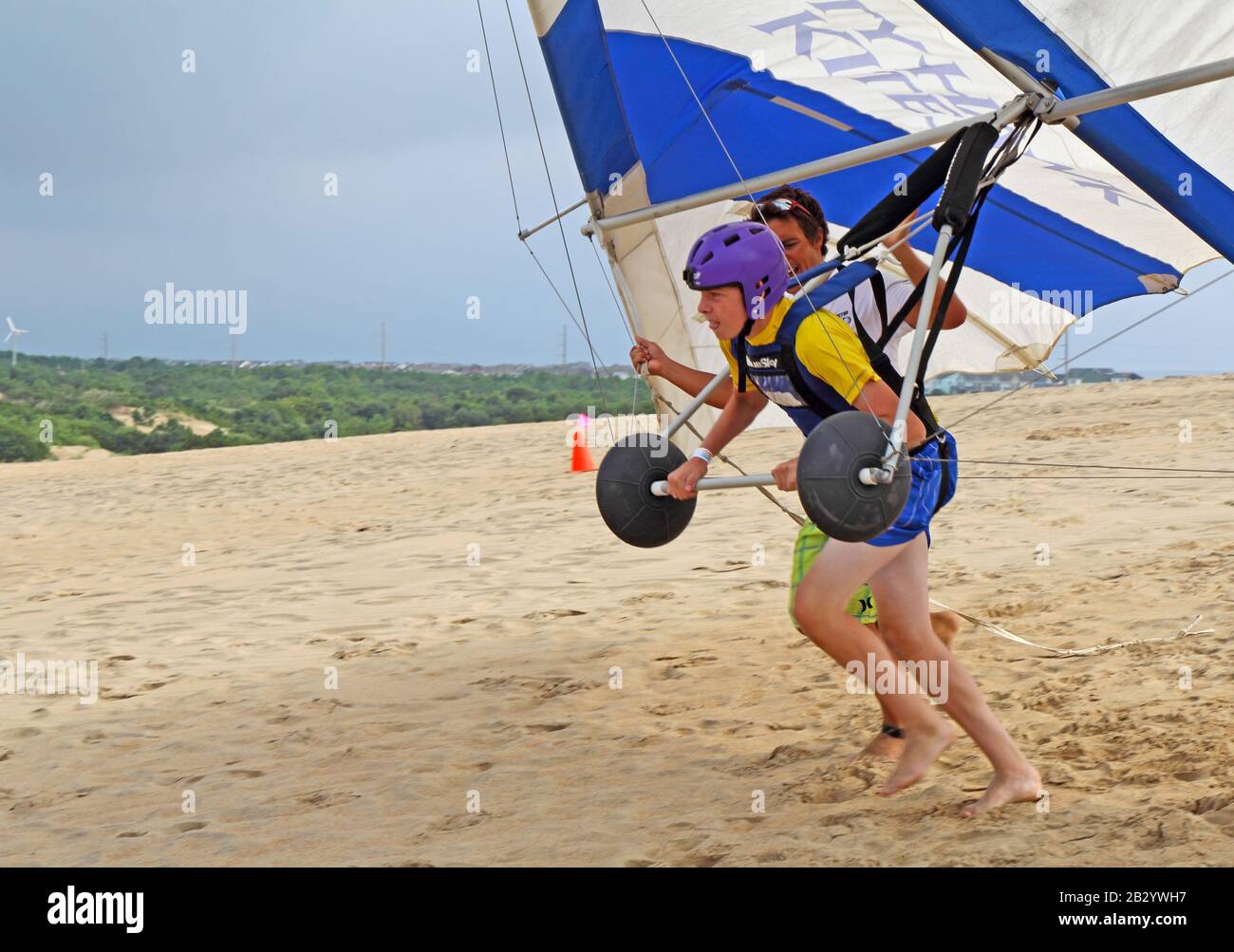 L'étudiant se prépare au décollage avec un instructeur de l'école Kitty Hawk Kites Hang Gliding sur les dunes de sable Banque D'Images