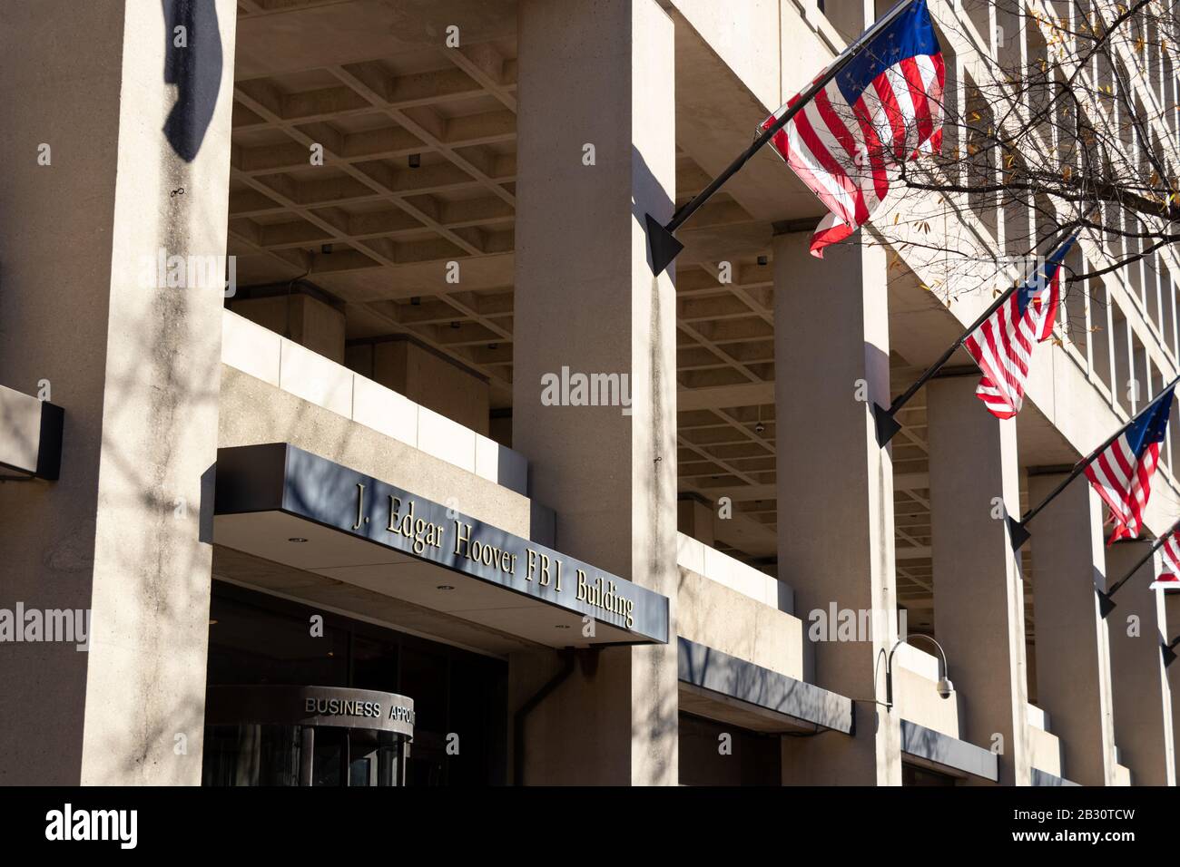Panneau au-dessus de l'entrée de l'édifice du FBI J. Edgar Hoover, des drapeaux américains ont vu se foutir en arrière-plan. Banque D'Images