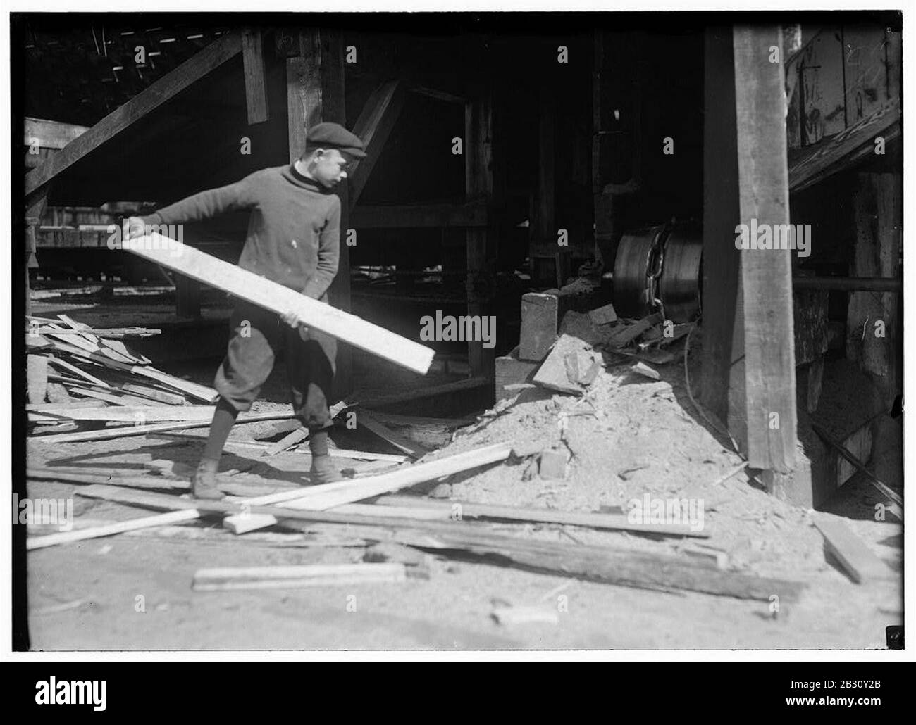 General Utility Boy À Miller & La Scie-Moulin De La Canda 14 ans (dit-il). Une partie du temps il jette des dalles dans la chute qui a la chaîne les transportant à la scierie. Je l'ai vu aider un homme Banque D'Images