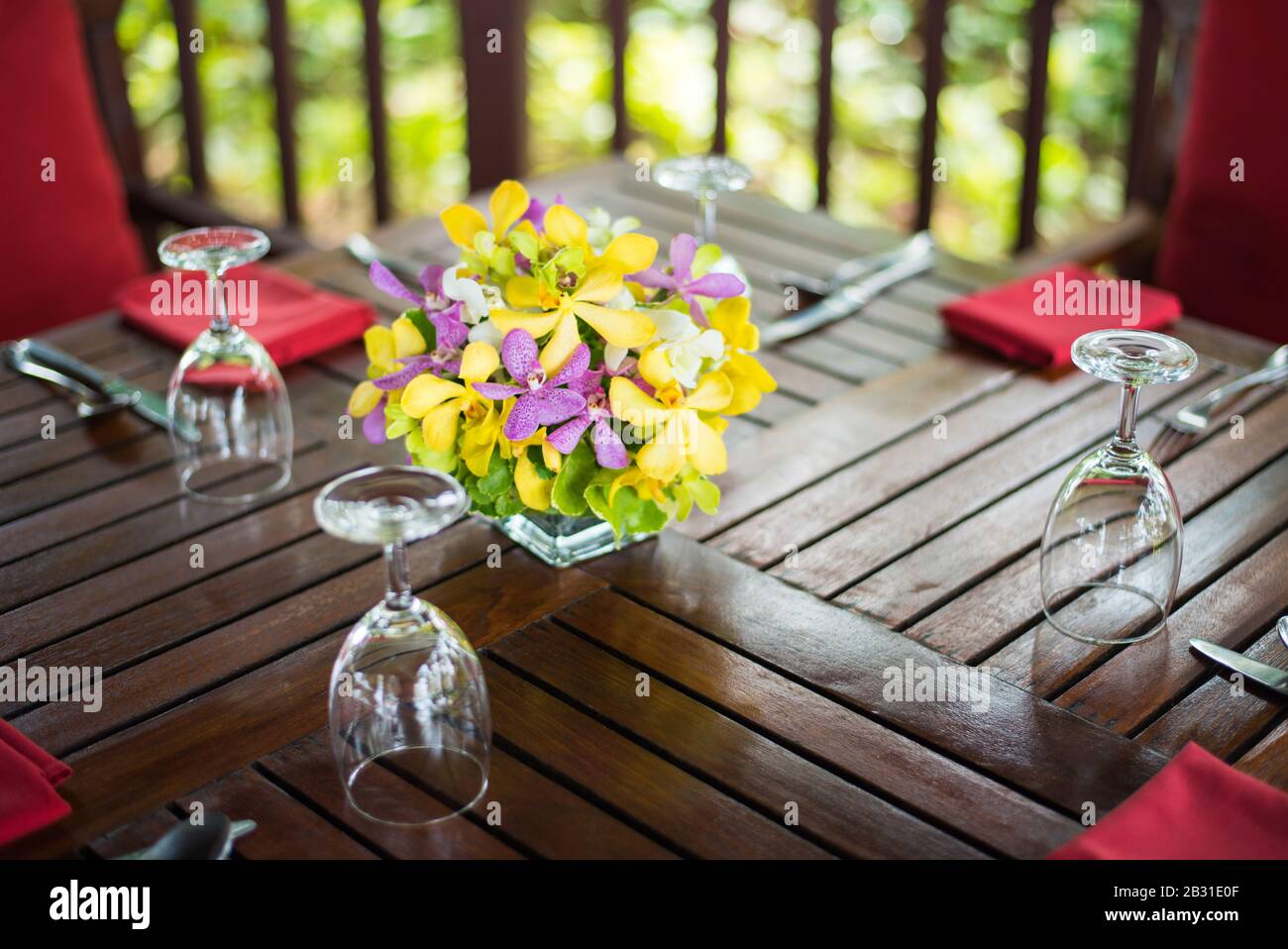 Magnifique bouquet d'orchidées coloré dans un vase en verre installé sur une table en bois à la réception du mariage en Inde. Banque D'Images