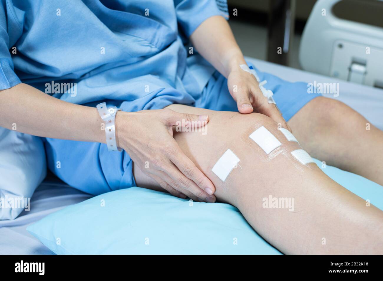 Jambe de patient de chirurgie du genou du ligament pcl allongé sur le lit  en paroisse à l'hôpital avec pansement stérile sur la plaie Photo Stock -  Alamy