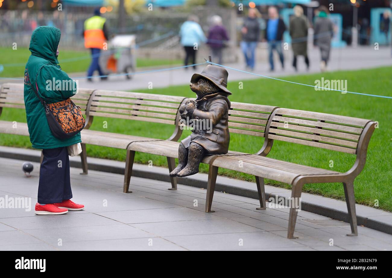 Londres, Angleterre, Royaume-Uni. Sentier statue de 'Scenes in the Square' - Paddington Bear sur un banc avec son sandwich marmelade Banque D'Images