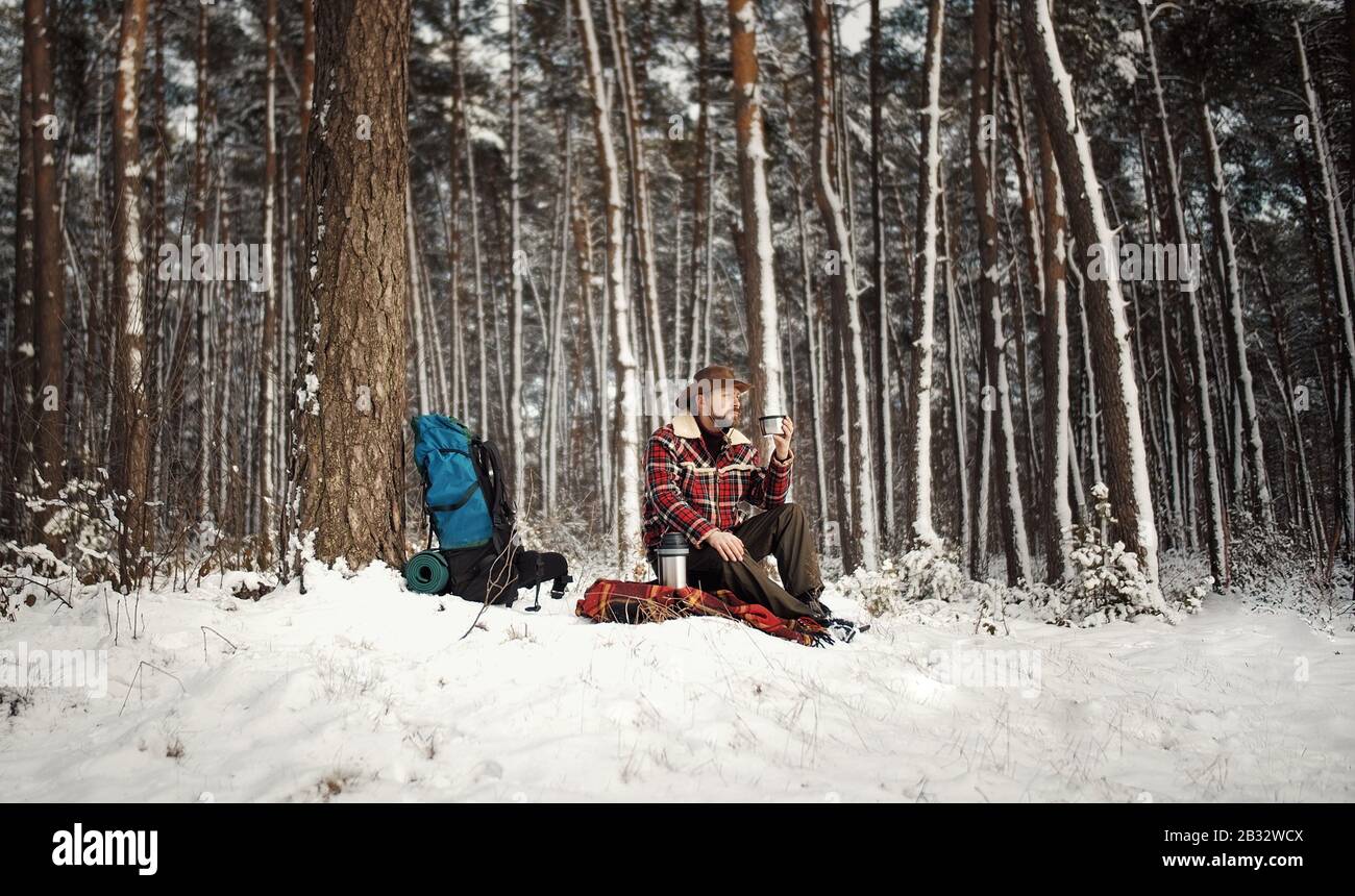 L'outdoorsman boire du thé, forêt d'hiver Banque D'Images