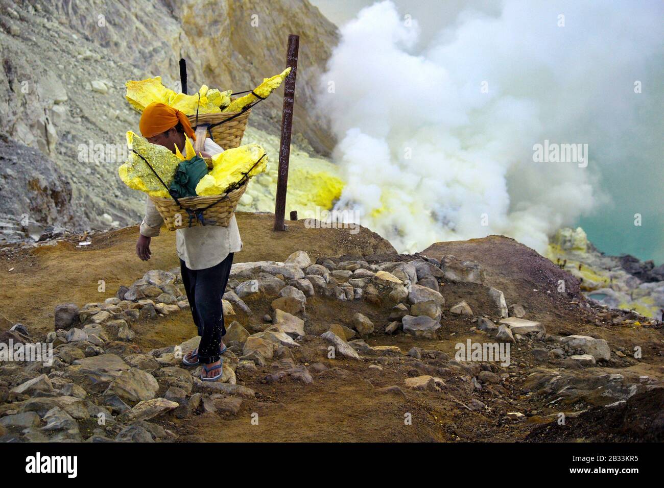 MINER RECUEILLANT DU SOUFRE SUR LE VOLCAN KAWAH IJEN À JAVA ISLAND-INDONÉSIE Banque D'Images