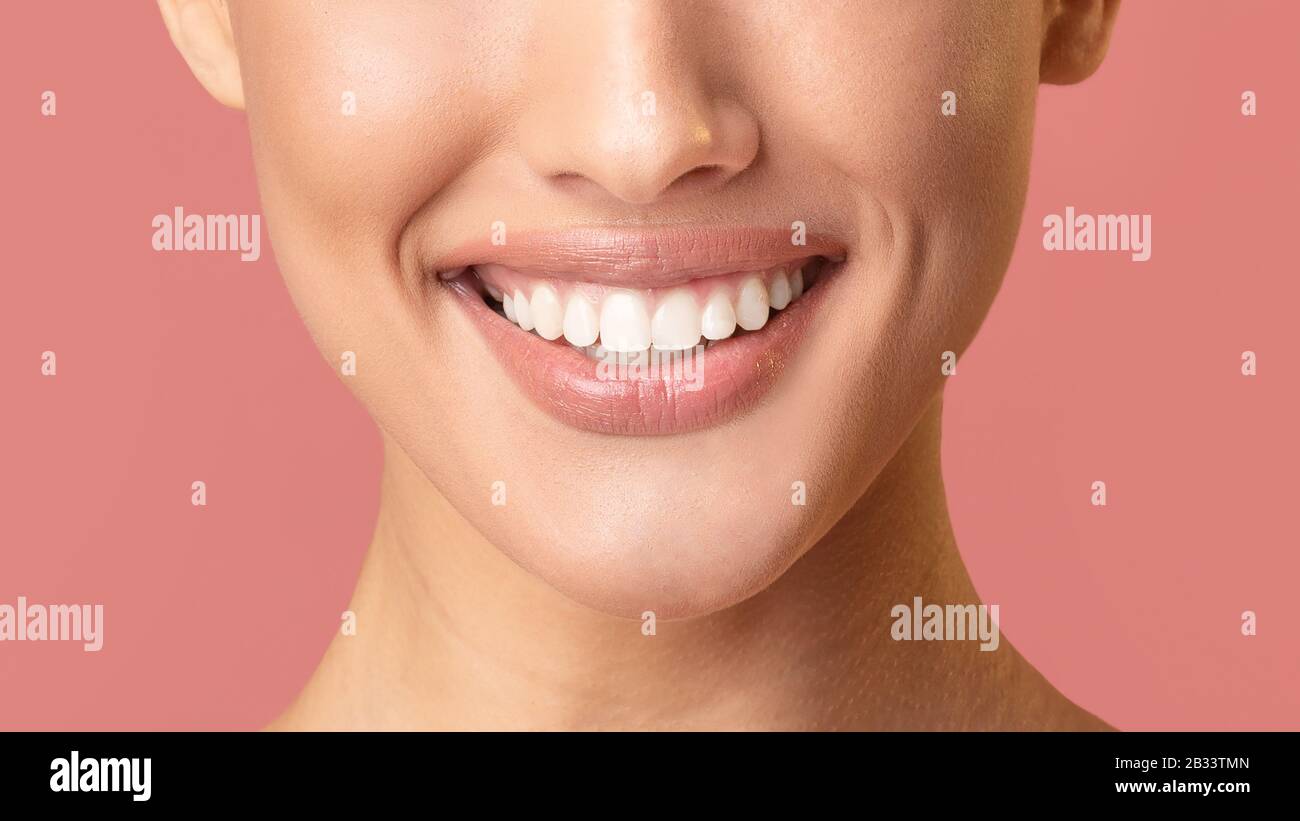 Smiling De Fille Non Reconnaissable Montrant Des Dents Blanches Parfaites Sur Fond Rose Banque D'Images