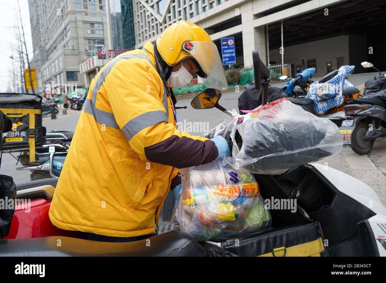(200304) -- NANJING, le 4 mars 2020 (Xinhua) -- Le livreur À Emporter Chen Kai a placé des marchandises dans le conteneur de sa moto à Nanjing, capitale de la province du Jiangsu en Chine orientale, le 19 février 2020. Chen Kai, 33 ans, travaille comme livreur à emporter à Nanjing depuis près de quatre ans. Durant cette période spéciale de lutte contre la nouvelle maladie du coronavirus (COVID-19), Chen et ses collègues ont essayé de mieux servir les citoyens qui restent à la maison. Dans un effort pour réduire le risque d'infection pour les clients et eux-mêmes, ils suivent la prévention et le contrôle stricts m Banque D'Images