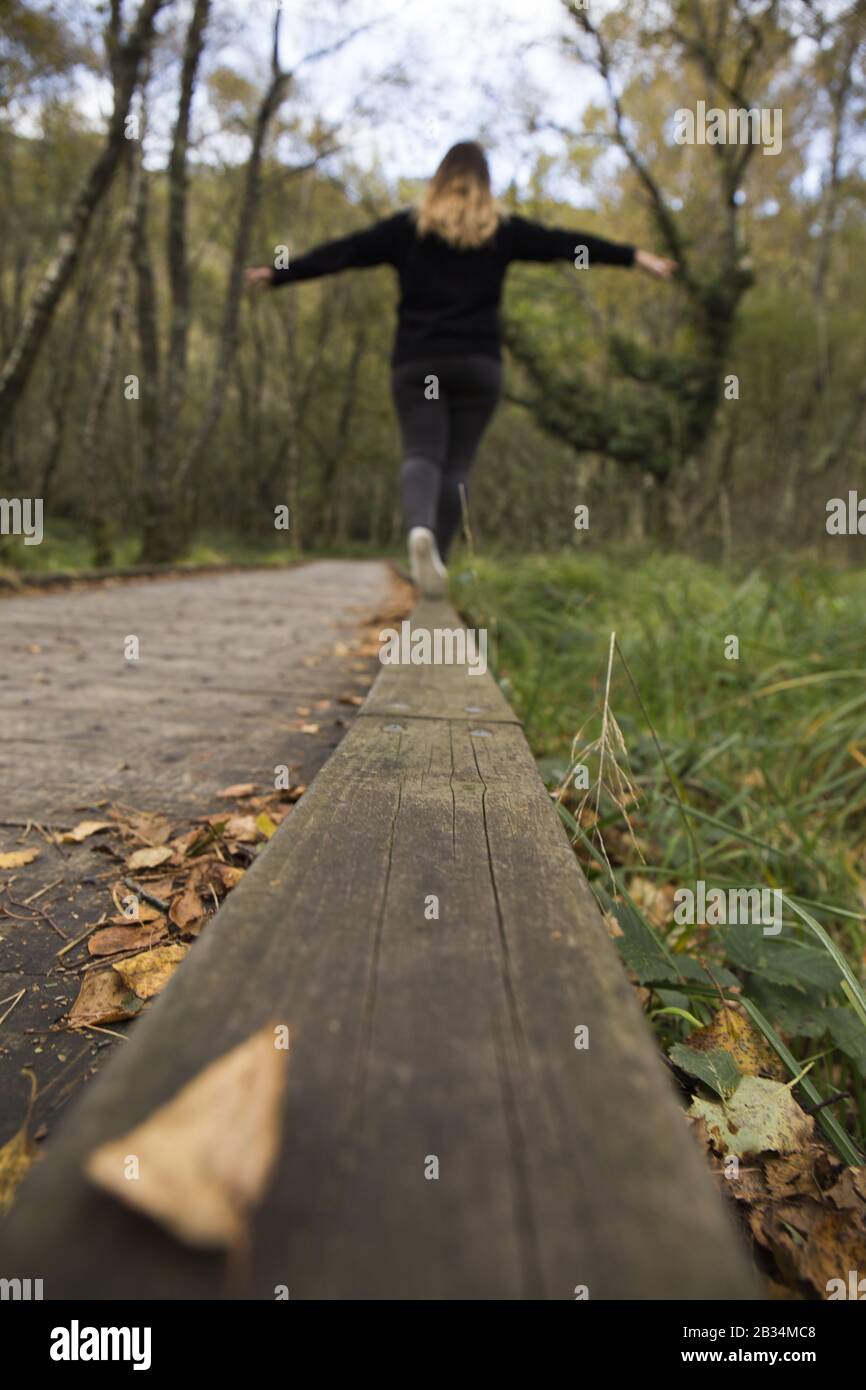 femme fait l'équilibre sur une passerelle en bois Banque D'Images