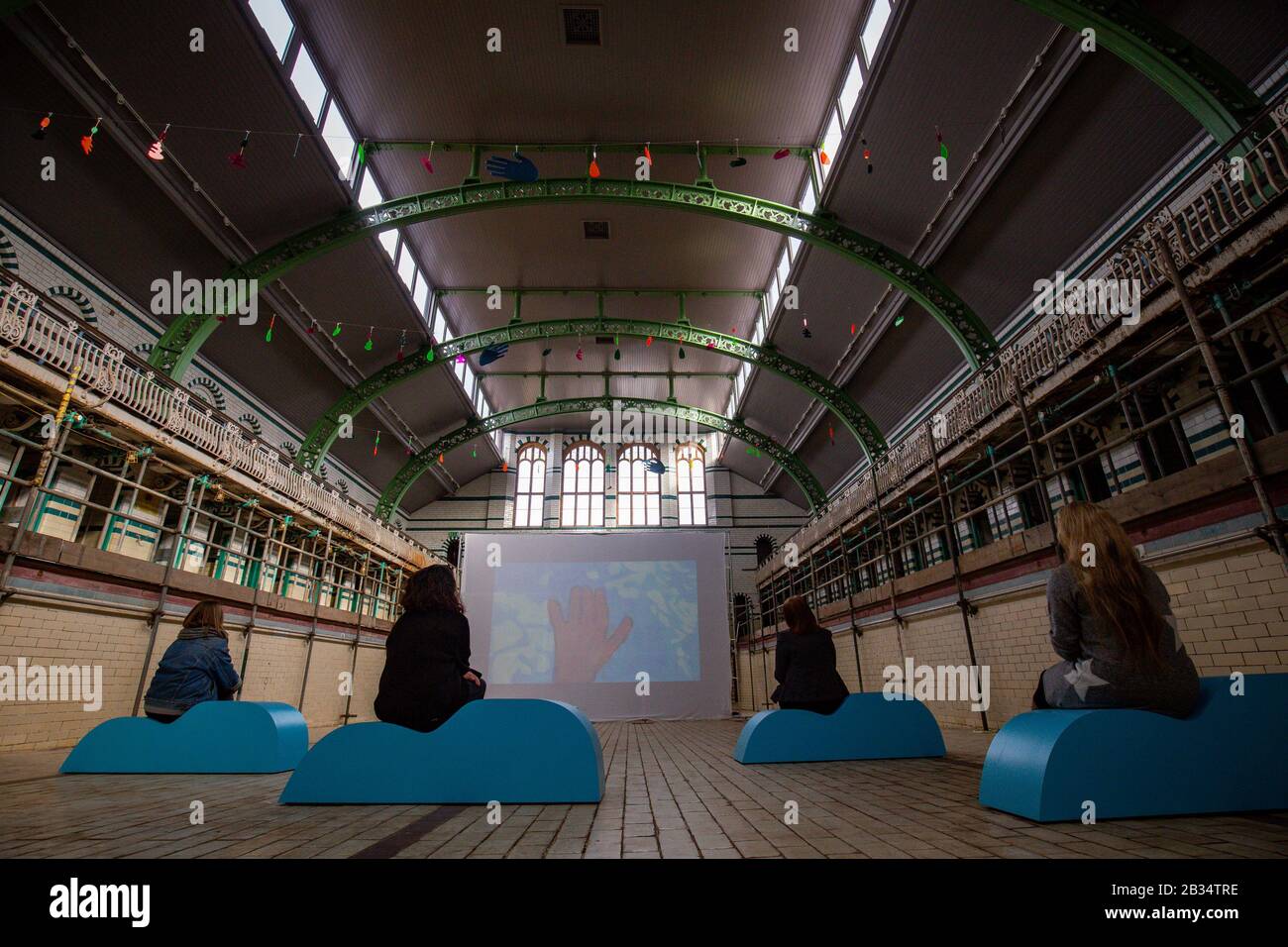 Les membres de l'installation d'art réfléchissant spéculaire à Moseley Road Baths, Birmingham, qui présente des animations peintes à la main créées par 500 personnes locales en collaboration avec la National Trust. Banque D'Images