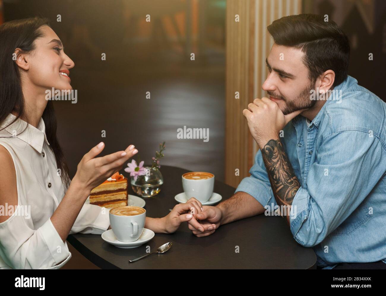 Petit Ami Et Petite Amie Parler Et Avoir Des Boissons Au Café Dans La Cafétéria Banque D'Images