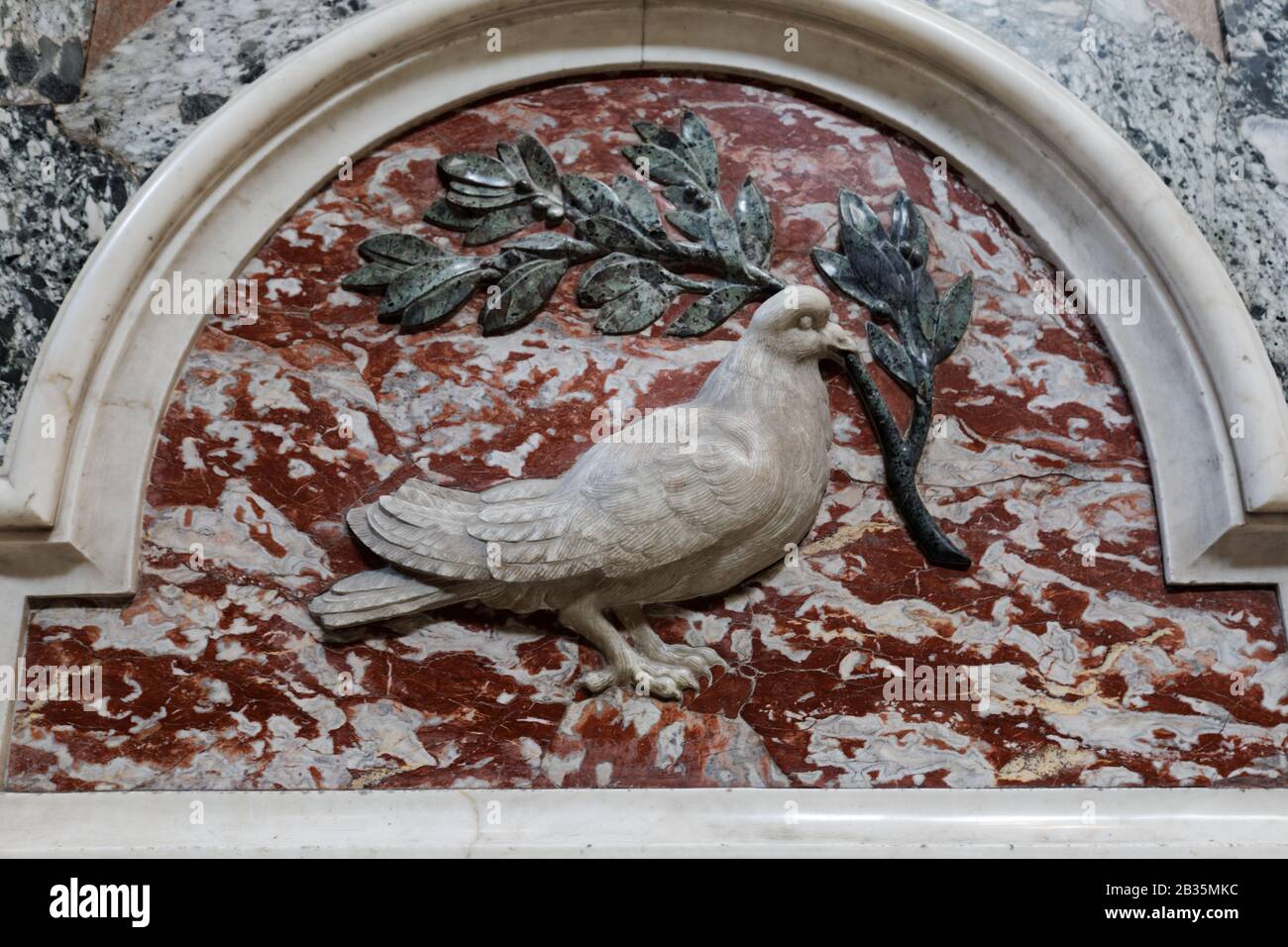 Colombe de paix, colombe blanche tenant un relief de branche d'olivier d'un mur de la basilique Saint-Pierre dans la ville du Vatican Banque D'Images