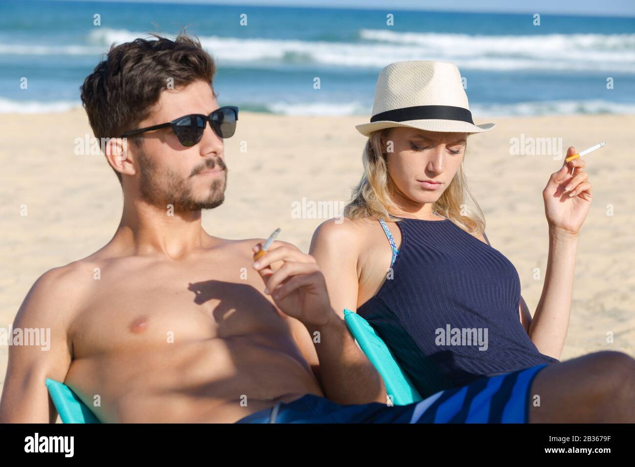 jeunes couples fumeurs sur la plage Banque D'Images